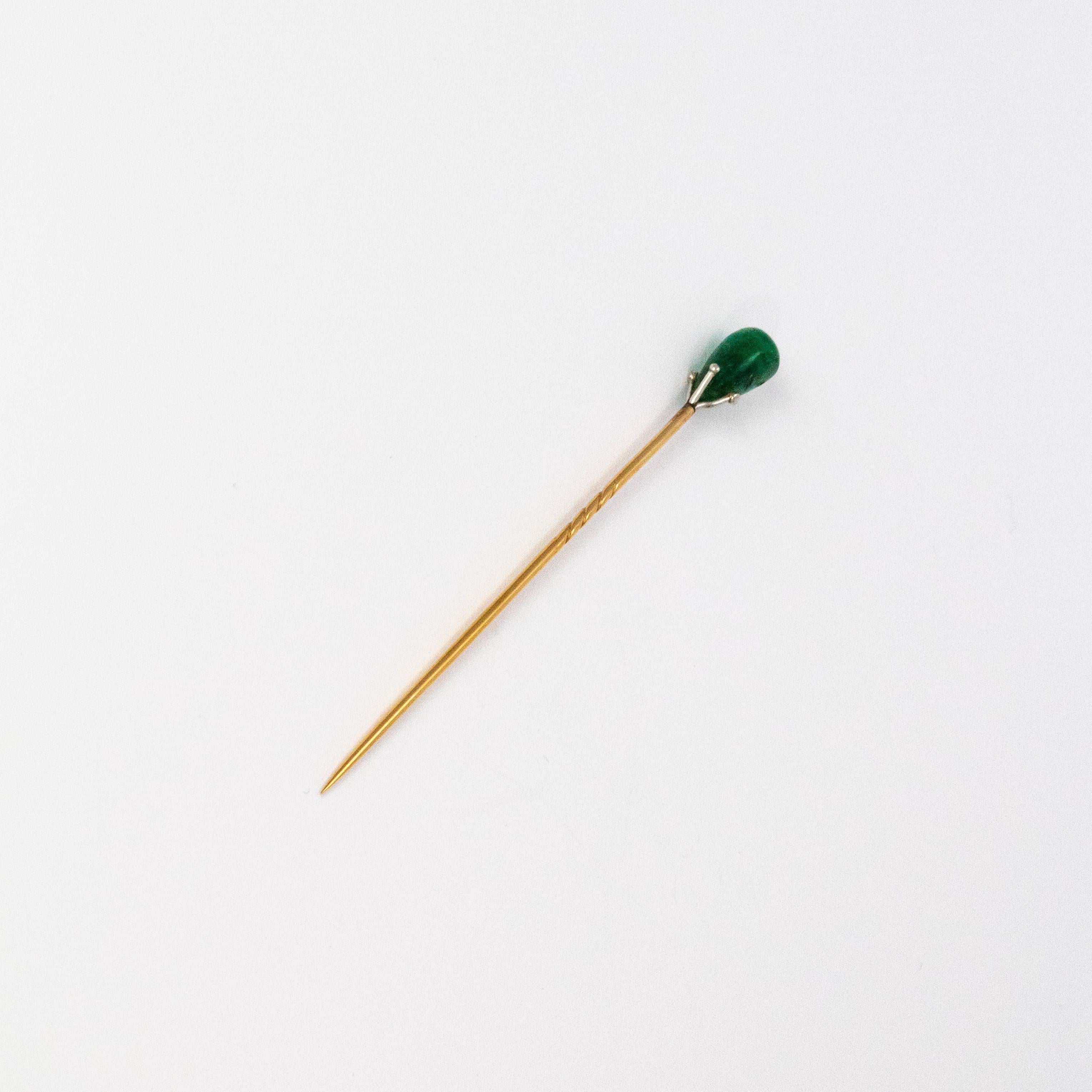 A pretty stick pin brooch from the Edwardian era. Topped with a fine green emerald in a platinum claw setting, the pin is modelled in 18 karat yellow gold. This pin comes in its fantastic original box.