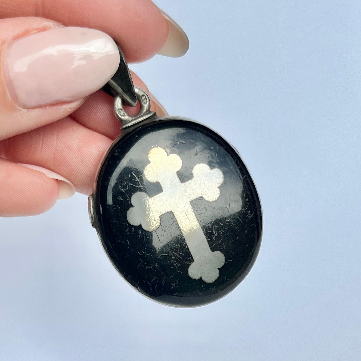 The enamel on this locket is black and wonderfully glossy, it really makes the silver pop. The locket also holds a cross on the front. The back of the locket is simply coated in the black enamel. 

Locket Dimensions inc loop: 32x50mm

Weight: 21.5g