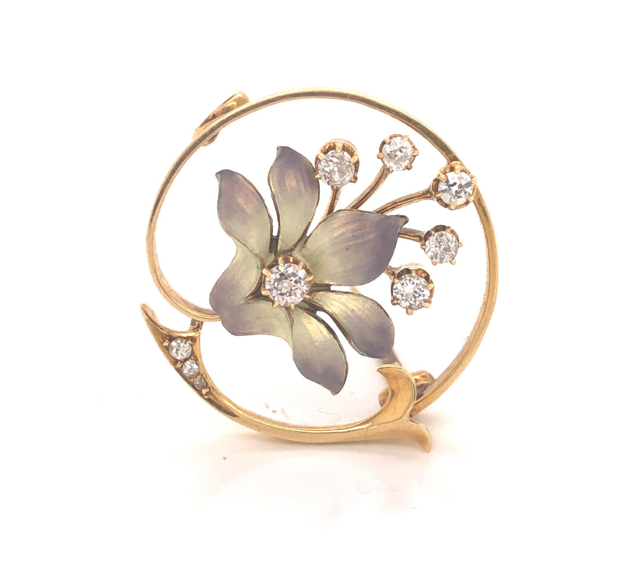 Beautiful circular pattern is seen in this one of kind Edwardian brooch. The piece is highlighted with one enamel orchid flower in the center. Gold and purple colors radiate off the floral design almost giving a irradescent look. Nine old mine cut