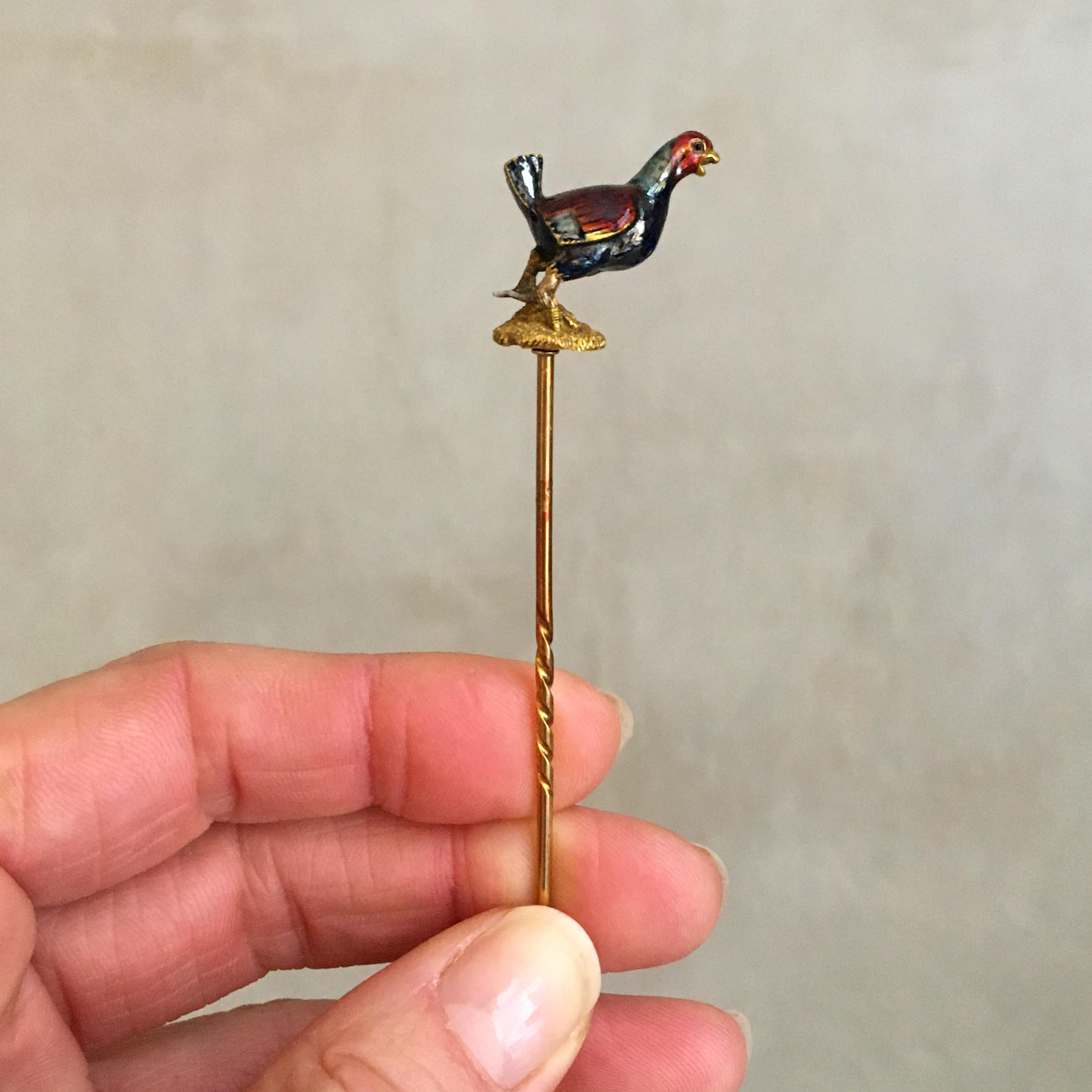 This lovelyantique Edwardian chicken stickpin or lapel pin is beautifully crafted in enamel in a colorful hue of red, blue, grayish and 18 karat gold. The enamel glaze varies in color from deep red to blue-grey with a gold rim. The wings are