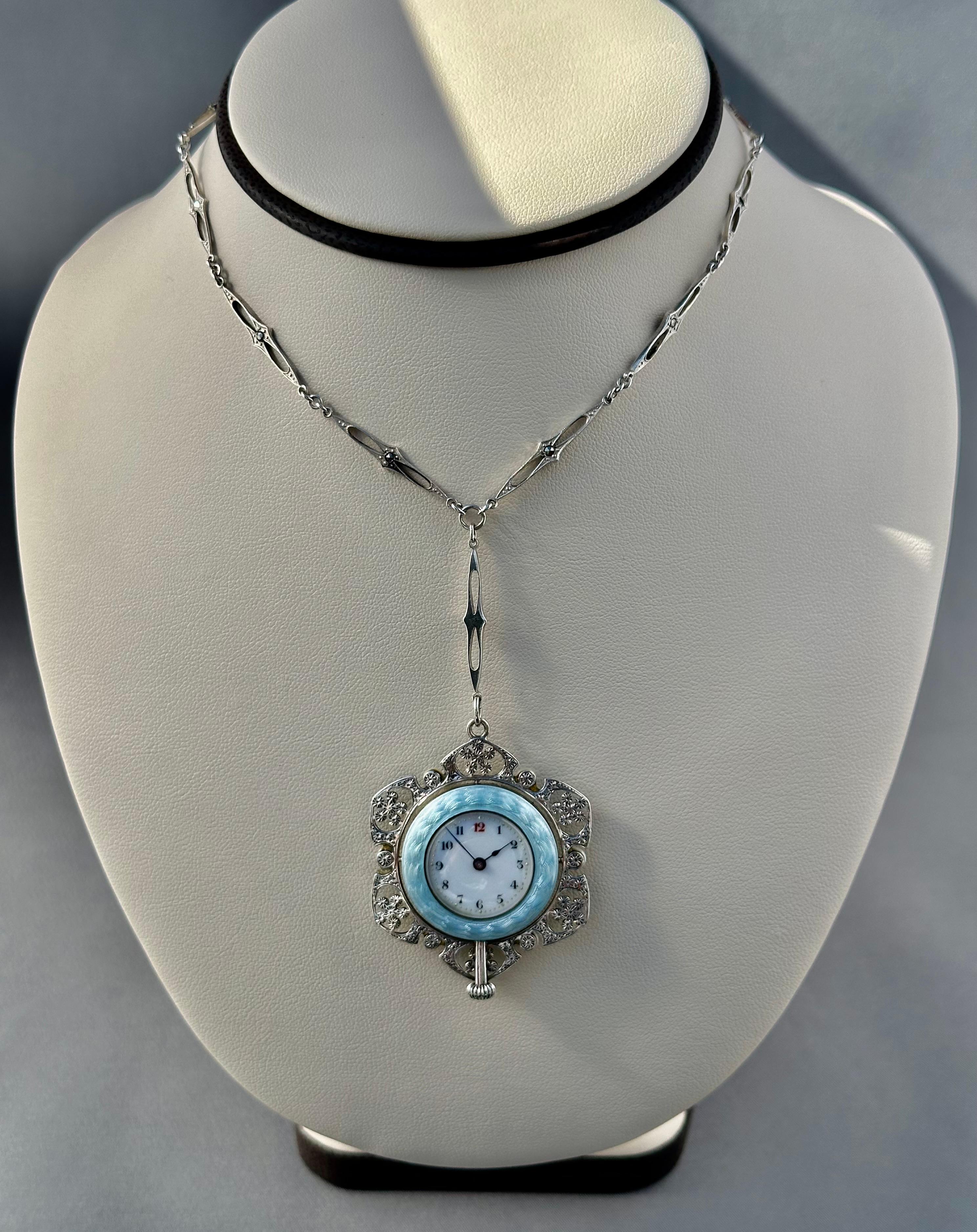 Edwardian vintage watch pendant in original condition! 
Designed in Sterling Silver, Marcasite and Natural Pearls Pendant Watch
Featuring a powder blue guilloche enameled with 24K Gold
In the Dial and Back Cover are hanging flowers and blue bow
The