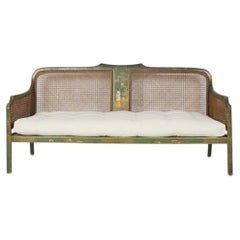 Edwardian English chinoiserie painted green caned sofa