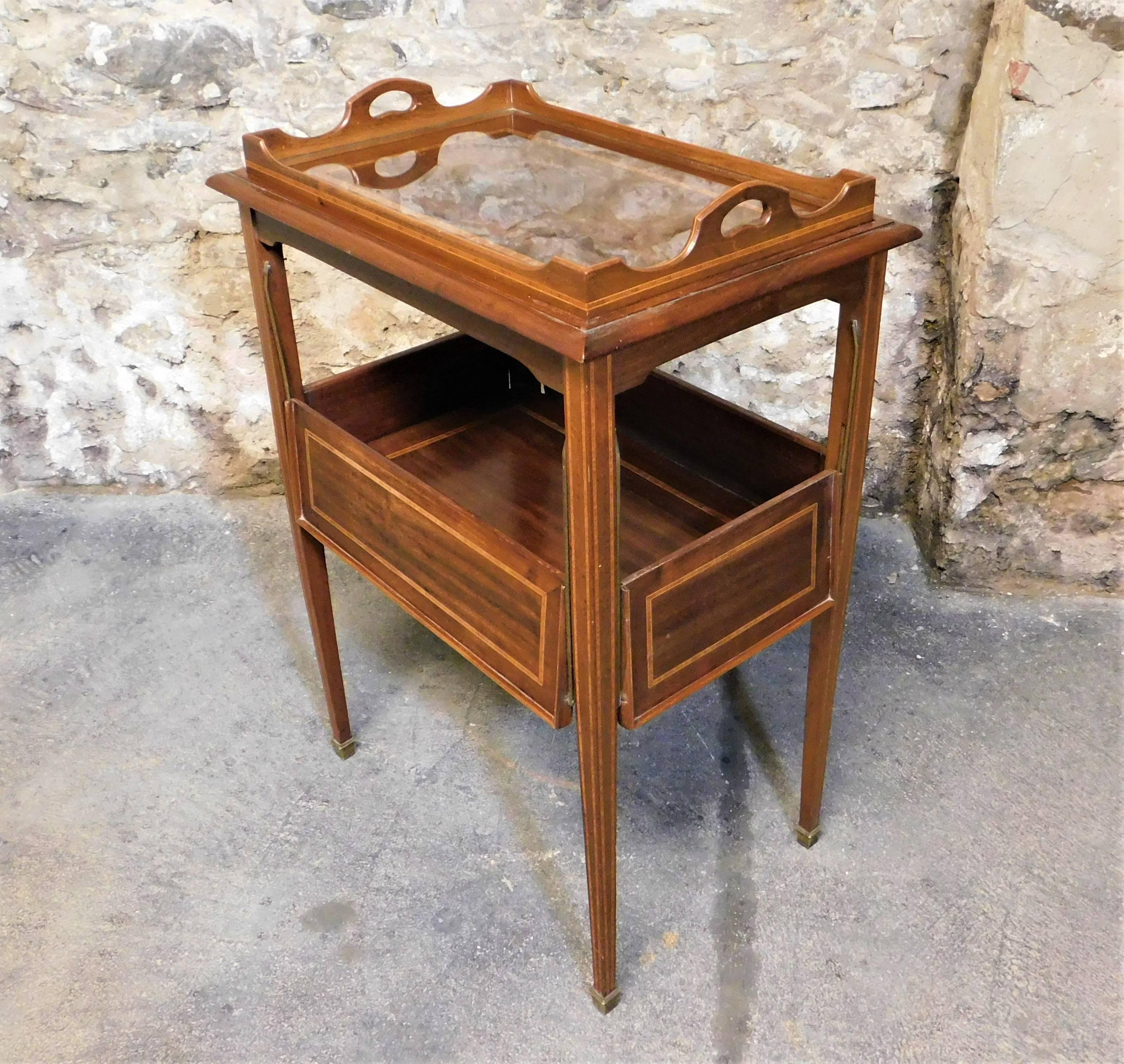 This very unique circa 1920s cocktail drink stand or tea table is made with crossbanded mahogany wood with inlaid lines. Has a glass serving tray that fits on top and the sides drop down.