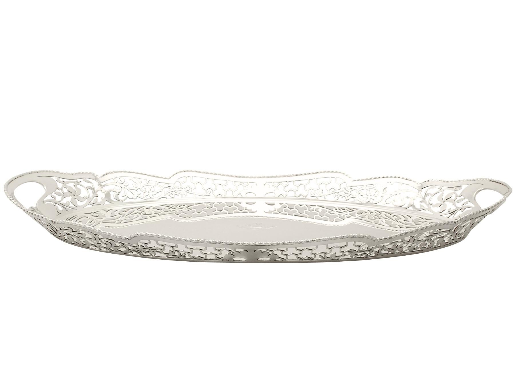 An exceptional, fine and impressive antique Edwardian English sterling silver gallery tray; an addition to our dining silverware collection.

This exceptional antique Edwardian sterling silver gallery tray has a plain oval form.

The surface of