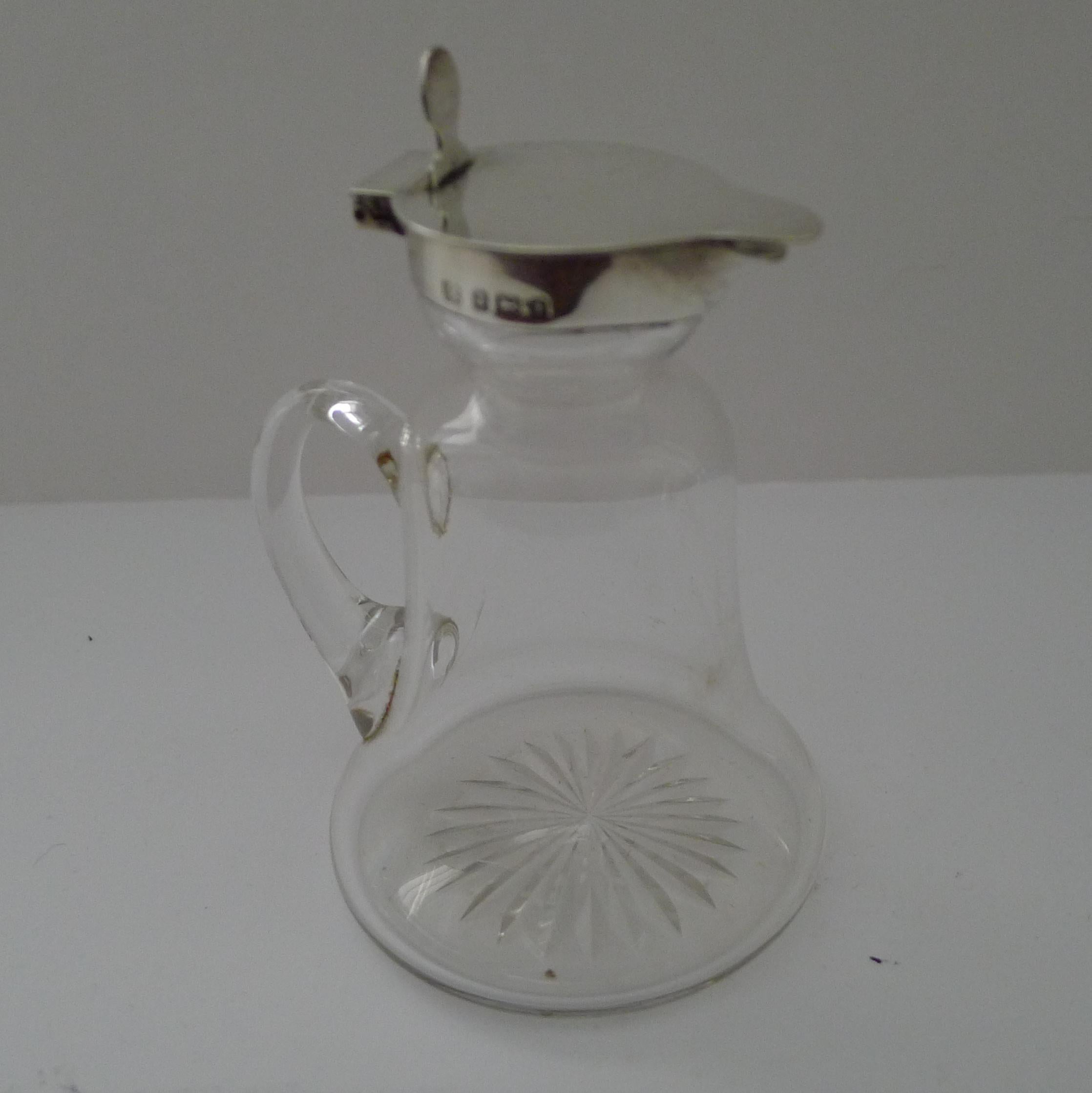 A charming little Edwardian Whisky Tot (also known as a Chotopeg) to accommodate a couple of measures of the spirit to take to bed.

The underside of the glass vessel is star cut and the collar and hinged lid is made from sterling silver fully