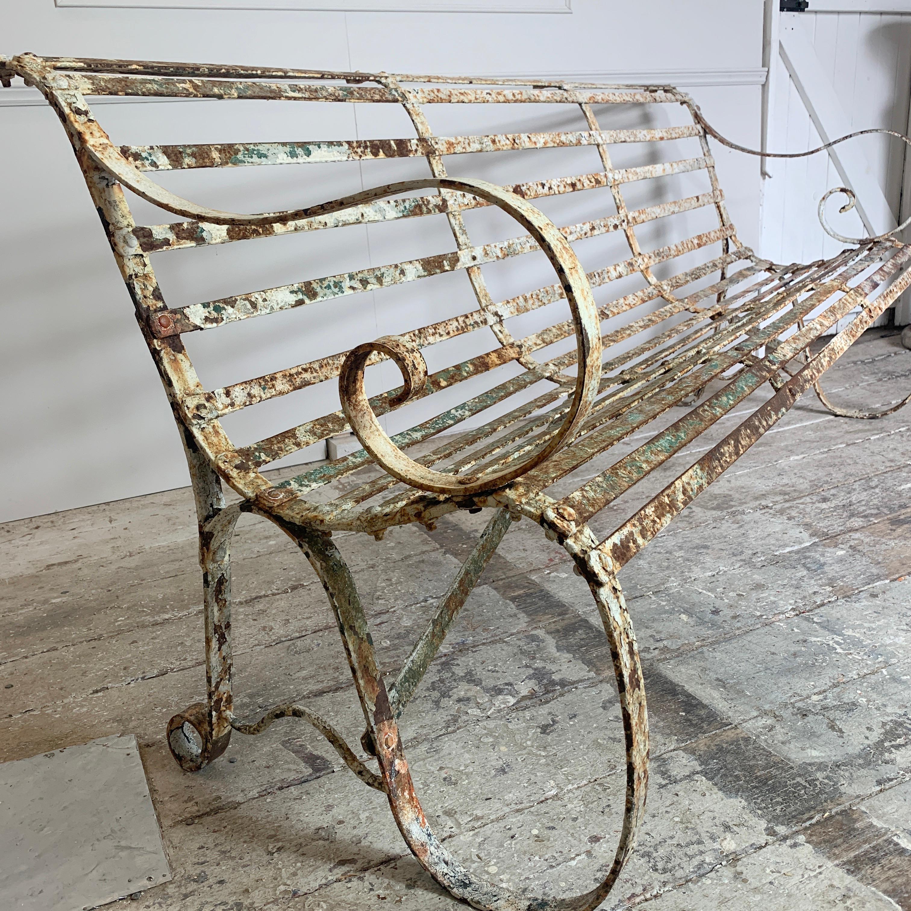 19th century English garden bench, originally from a cricket club
Beautiful Edwardian wrought iron strap work
The iron strapwork is used to give a really comfortable seat
This elegant shape has a curved seat and back, and scrolled arms
This is a
