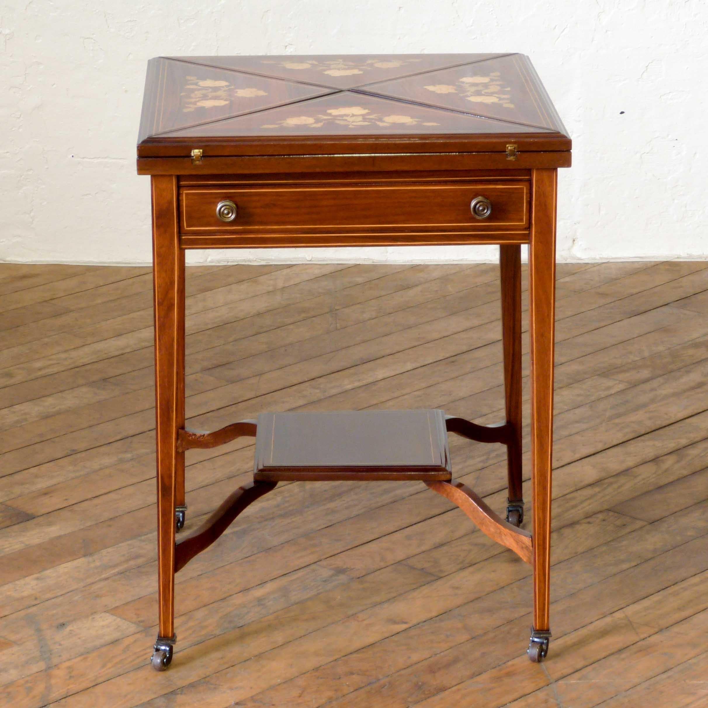 A lovely Edwardian mahogany card table of the envelope design. When opened it displays a baize surface to the centre and dished compartments. Sat on four legs with boxwood inlaid stringing, the original castors still evident, plus the stretchered