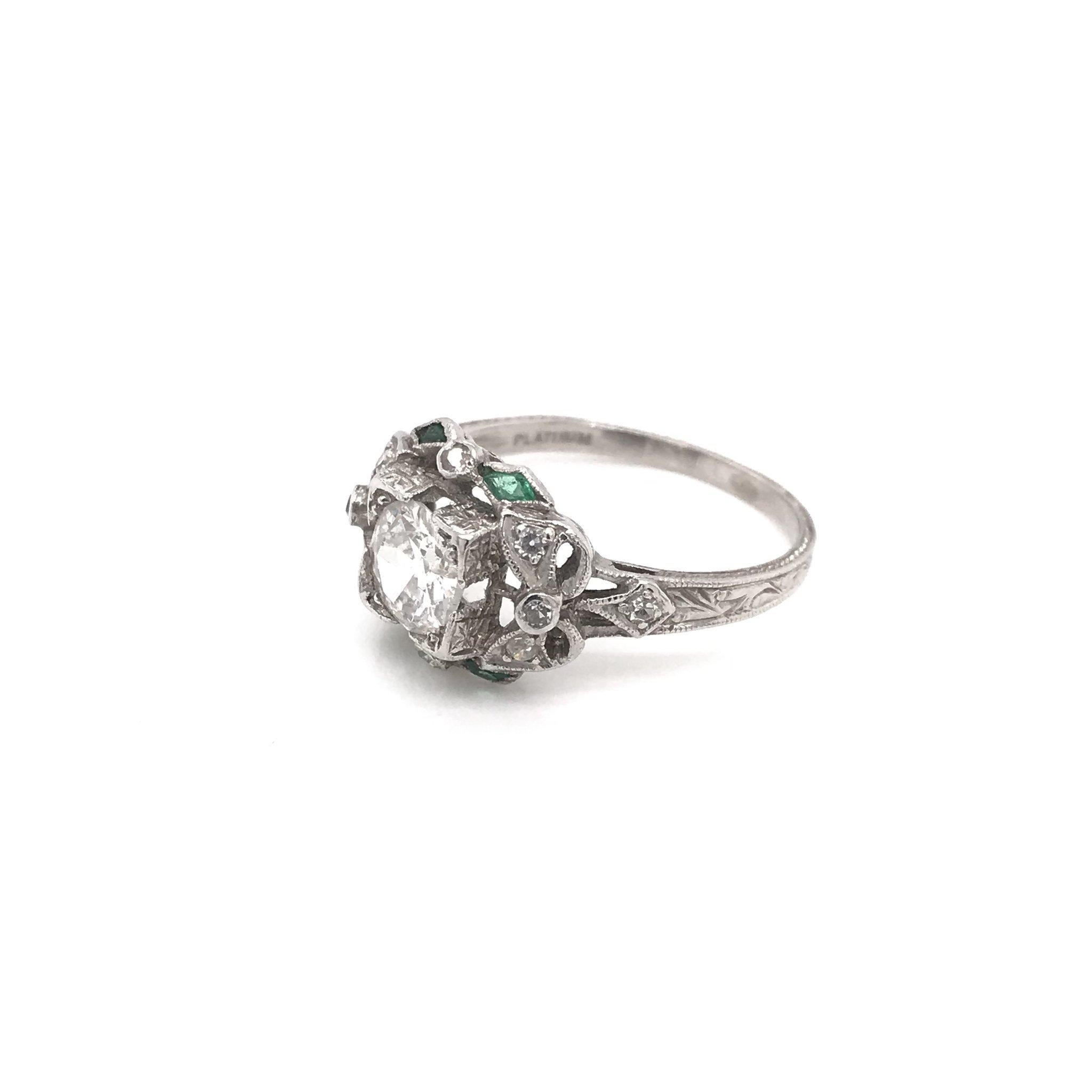 This exquisite antique piece was handcrafted sometime during the Edwardian design period ( 1900-1920 ). The platinum setting features a center diamond measuring approximately 0.90 carats. The center diamond grades approximately F in color, Vs1