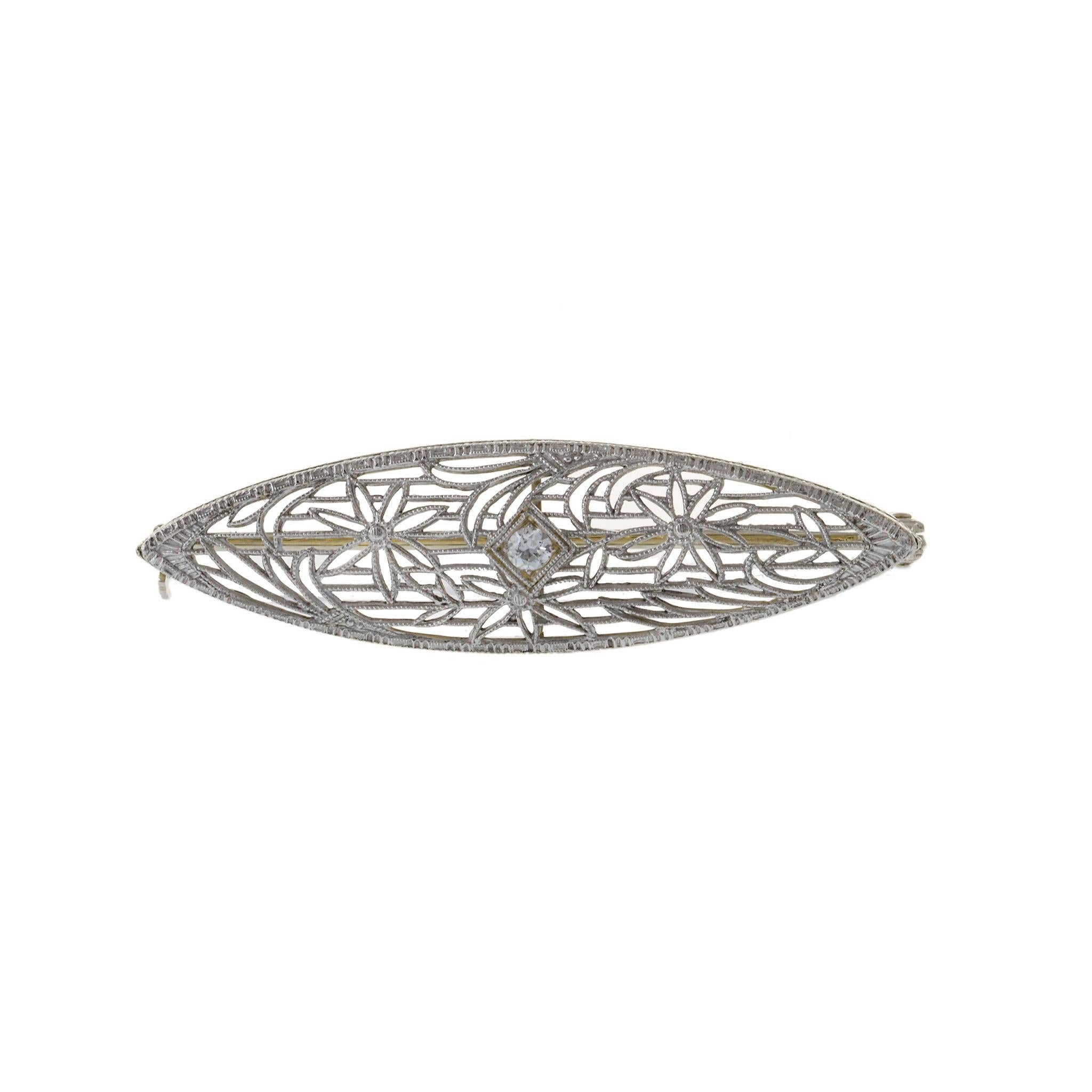Evoke the glamour of the Edwardian era with our exquisite Antique Platinum and 14kt Filigree Pin. Adorned with a stunning .07ct Old European Cut Round Diamond, this timeless piece exudes elegance and sophistication.