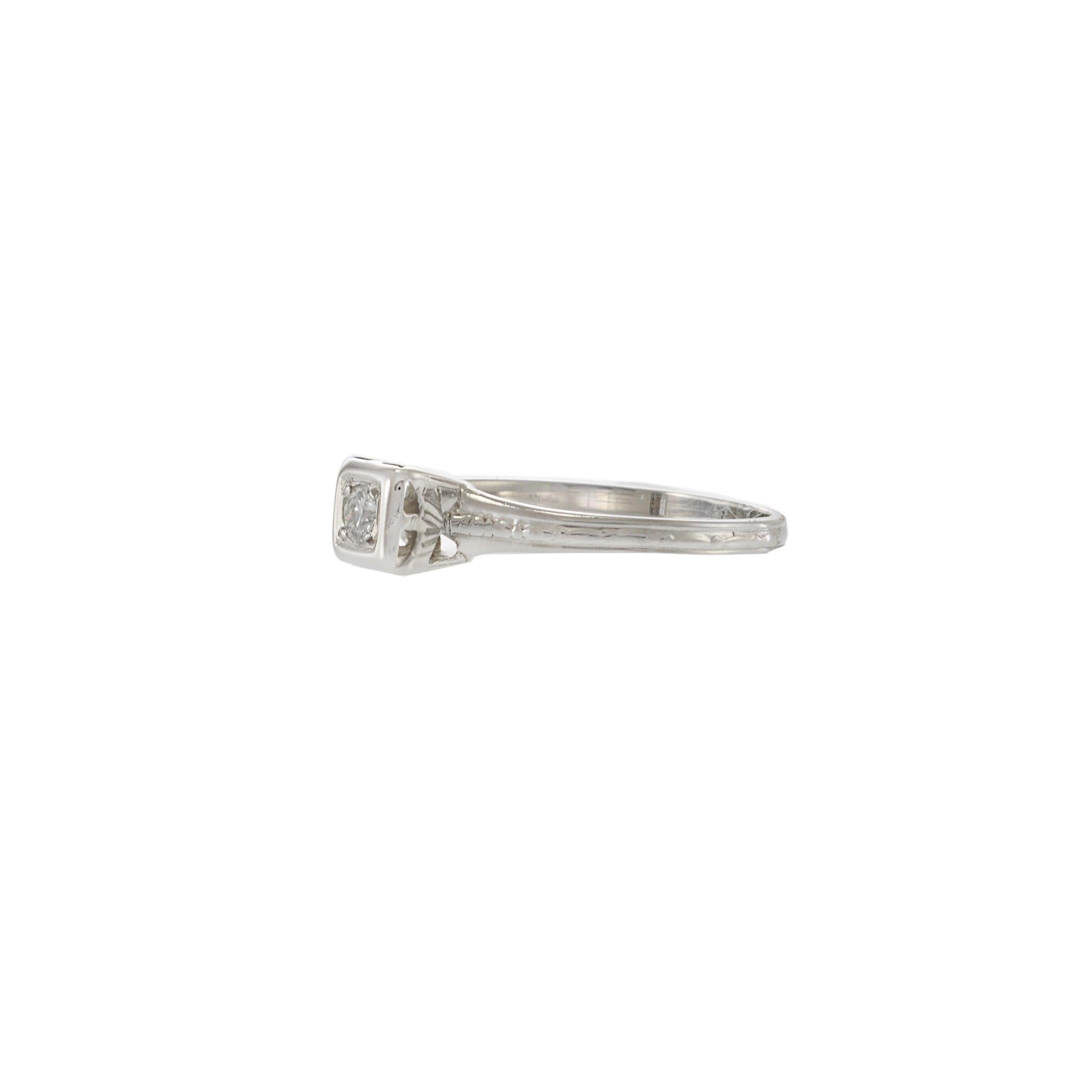 Cette bague ancienne de style édouardien est ornée d'un diamant de taille européenne ancien magnifiquement préservé, serti dans une monture carrée en platine. Réalisé en or 18 carats avec des gravures complexes le long des épaules, ses lignes