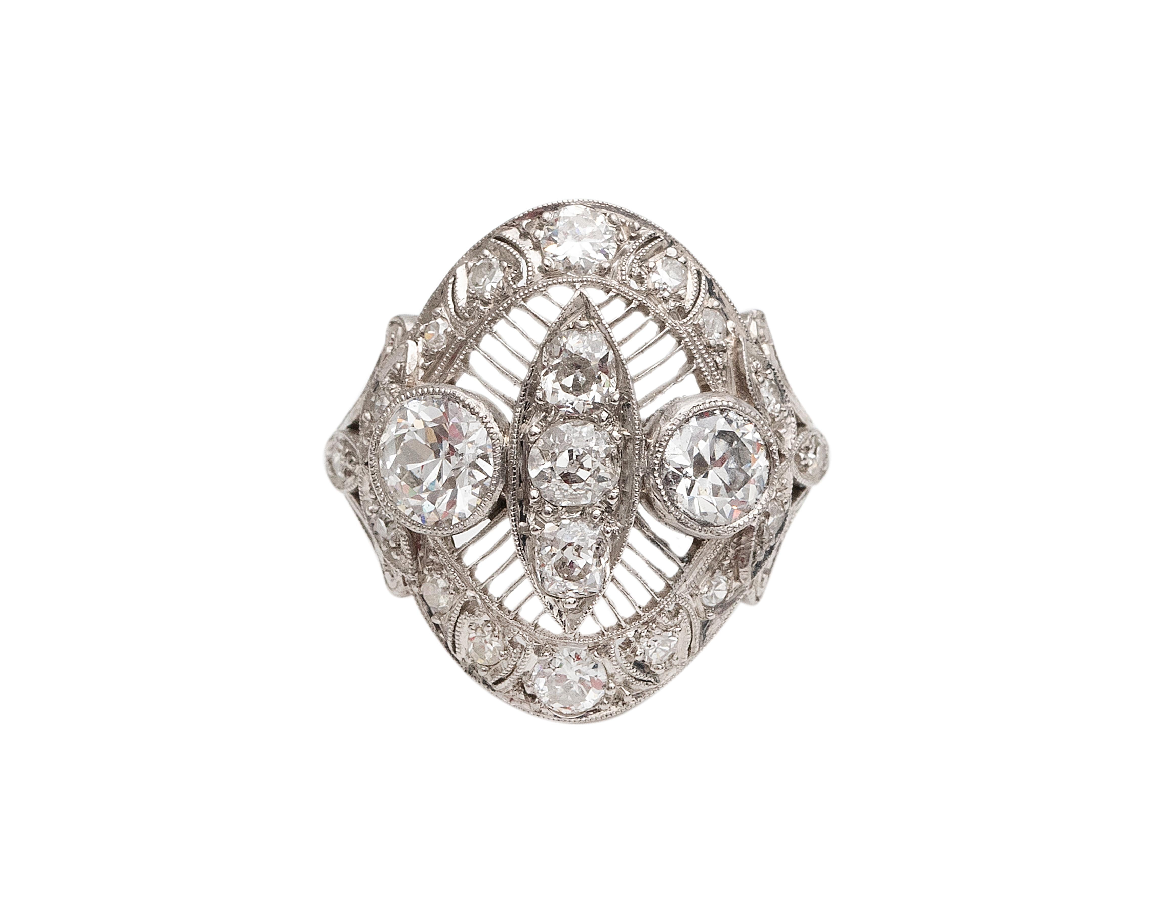 The detail in this antique platinum beauty is endless! The stunning 7 center diamonds take the stage as the side stones add even more sparkle without being too much. What a beautiful engagement or special occasion ring to add to your collection! The