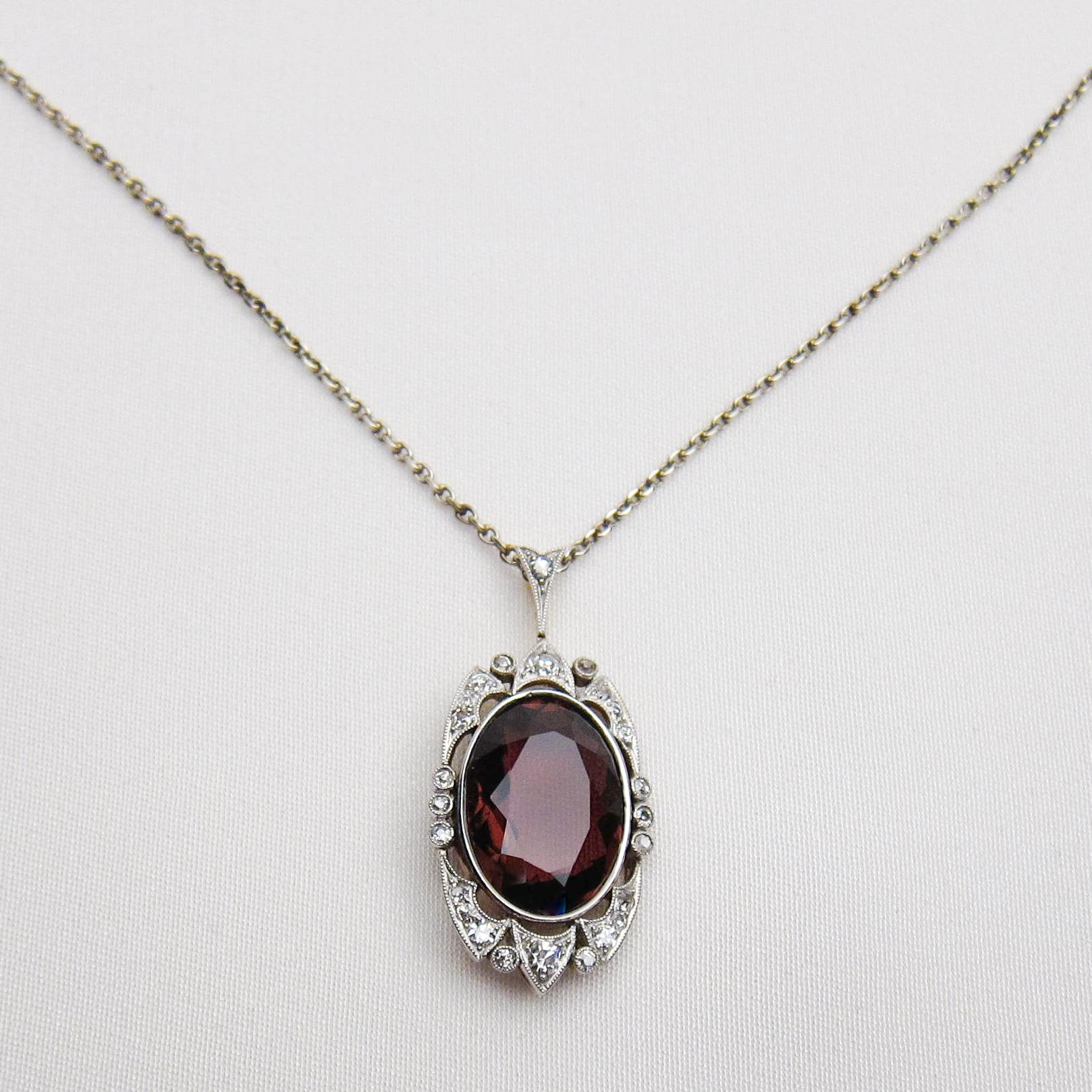 Circa 1910. This stunning 14KT and platinum Edwardian pendant features a lovely oval mixed-cut tourmaline weighing 6.51 carats. The tourmaline is surrounded with 25 single-cut diamonds weighing 7.13 carats with a VS2-SI1 and G-H clarity, accented