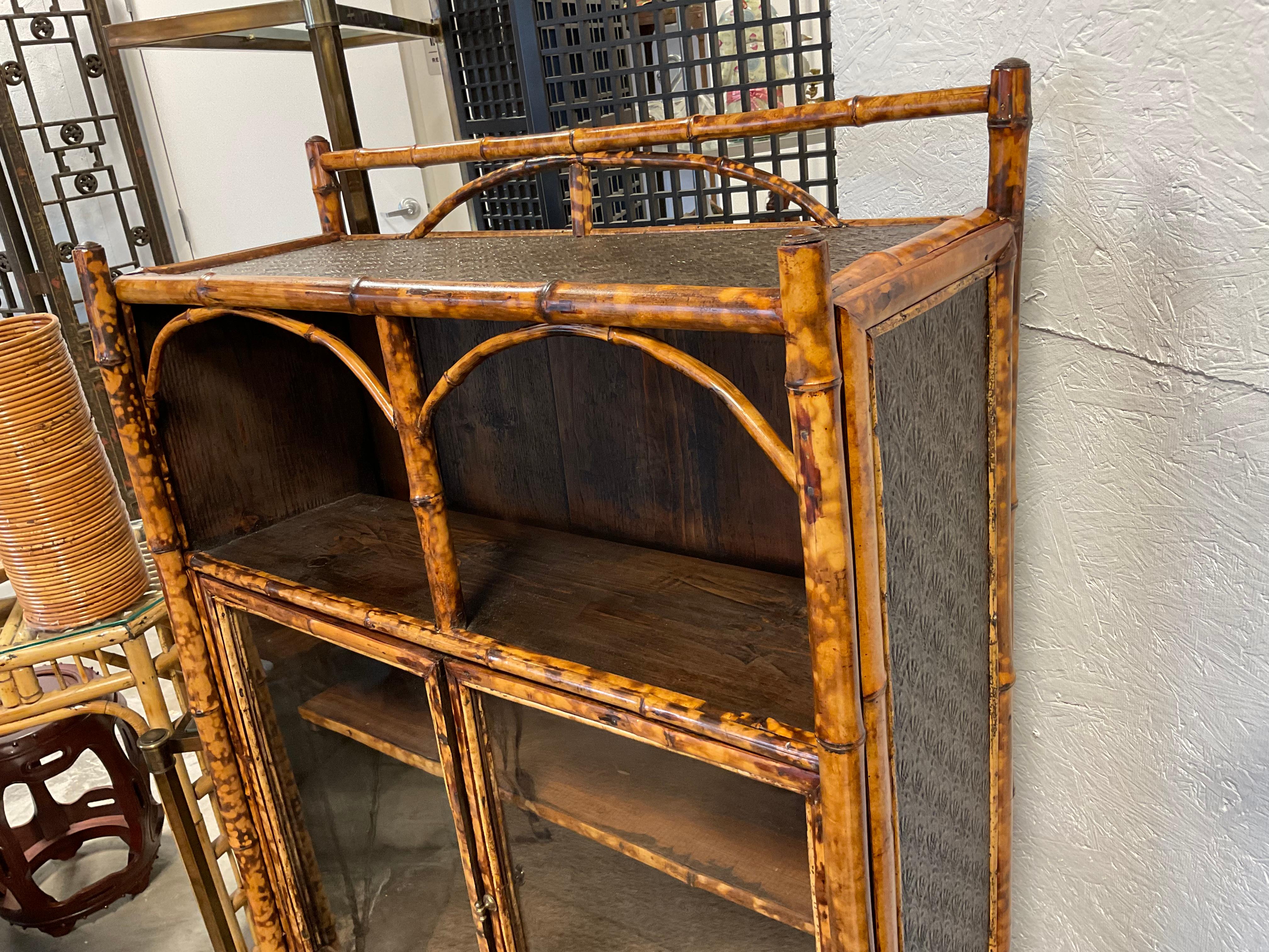 I have bought quite a few pieces of bamboo, over the years, but have never seen a piece, quite like this one. It has open shelving, glass encased shelving, and a single drawer. The piece has English embossed wallpaper, on the top, sides, and drawer