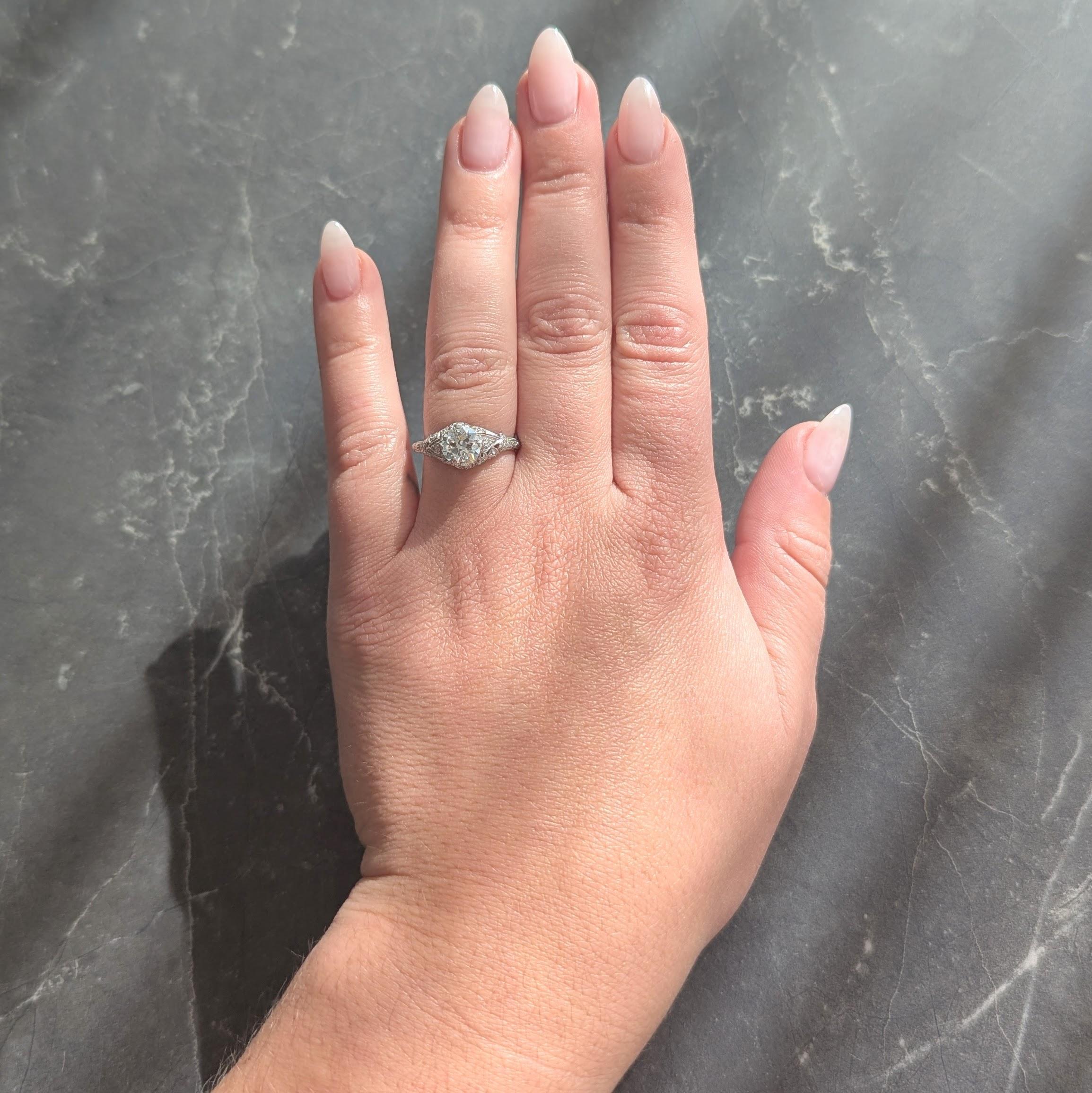 Centering an old European cut diamond weighing approximately 1.25 carats total - J color with VS2 clarity
Prong set in a pierced sweeping lily-of-the-valley gallery with ribbon shoulders
Bead set with single cut diamonds weighing approximately 0.25