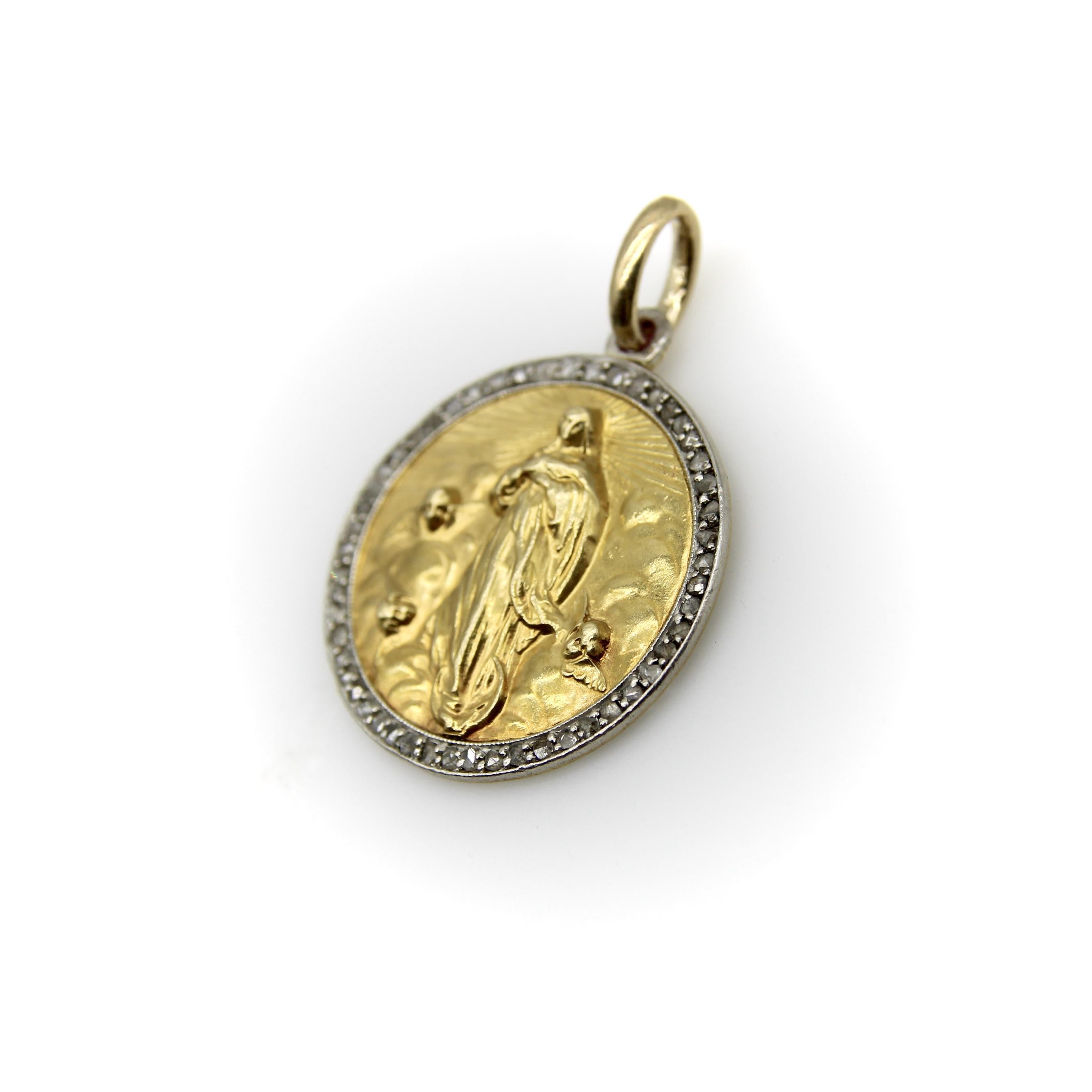 Circa 1912, questo pendente francese in oro 18 carati presenta un'immagine di Santa Maria circondata da diamanti incastonati nel platino. L'immagine ha una definizione e dei dettagli bellissimi. Maria sembra essere sorretta da una mezzaluna, mentre