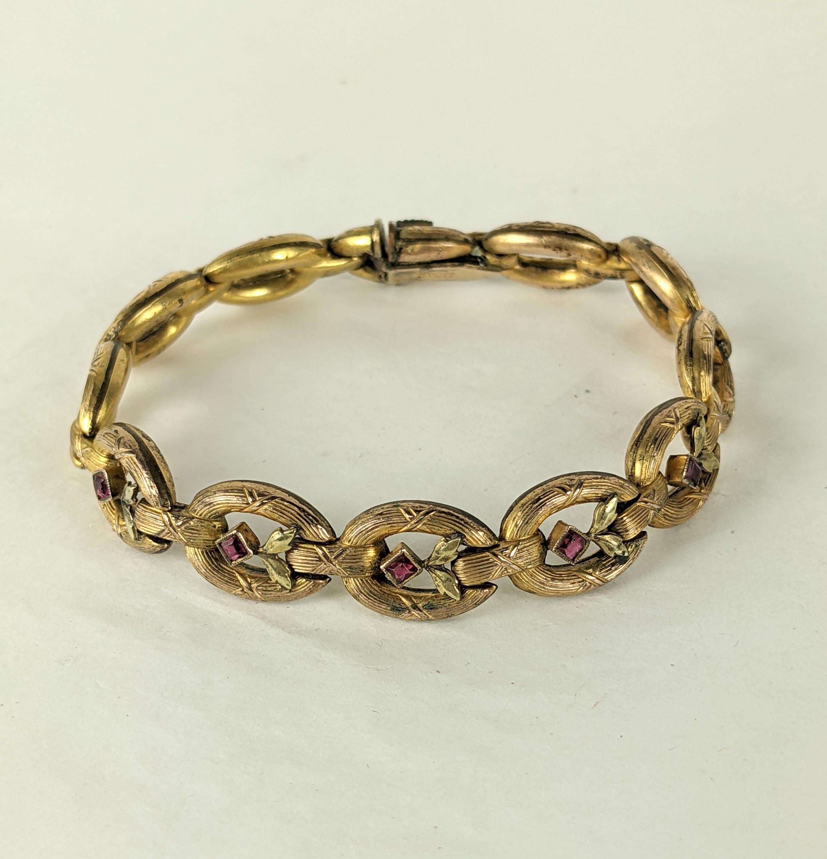 Elegante bracciale francese edoardiano a maglie in oro del 1910 circa. Maglia in tonalità oro con maglie centrali decorate con foglie in oro verde e paste di rubino.  
7