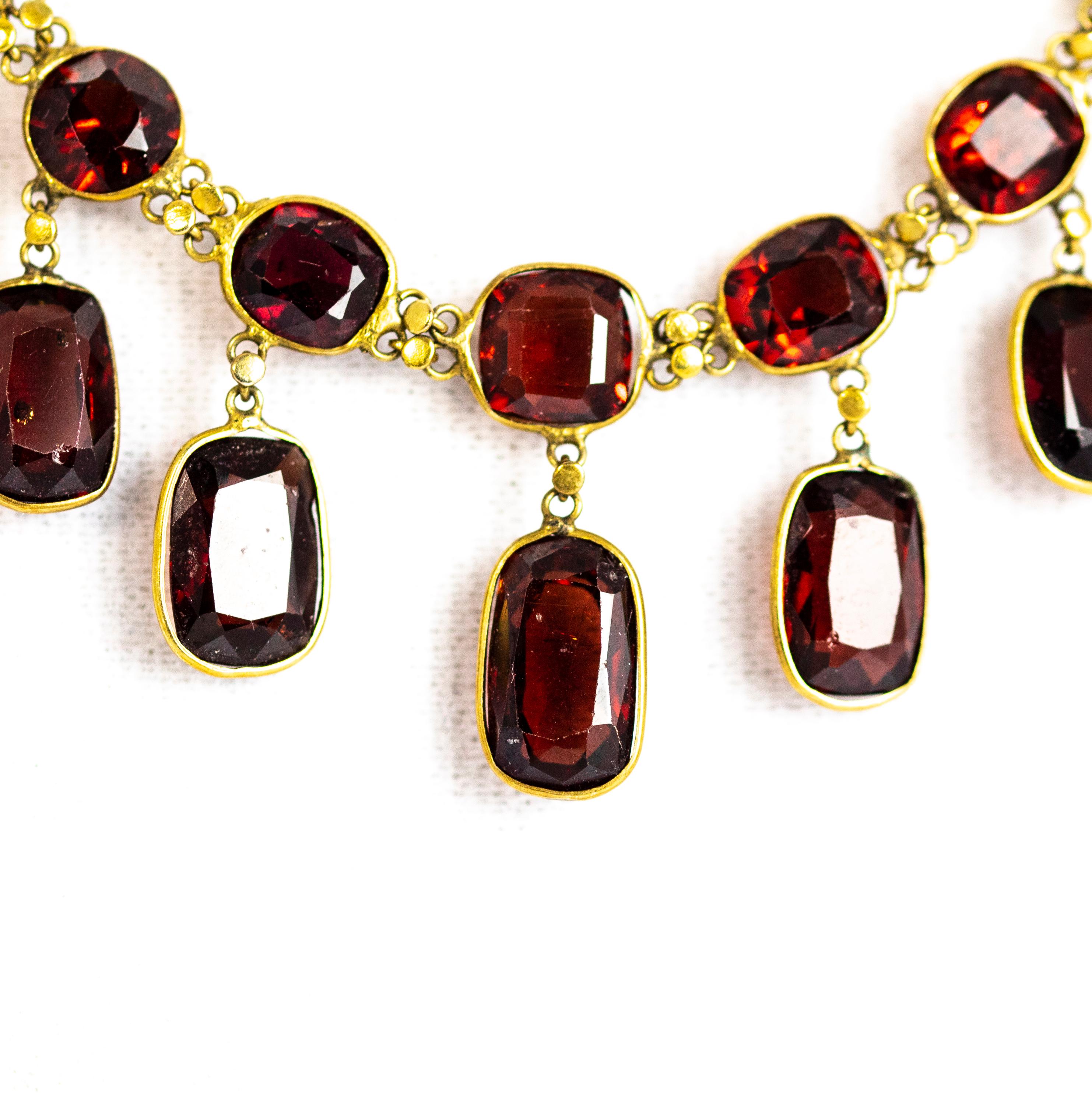 Stunning garnet necklace which holds a row of the deep red sparkling stones and each one of these stones had a drop attached to it. This fringe style necklace is a lovely length and sits flat to the skin.

Length: 16inches