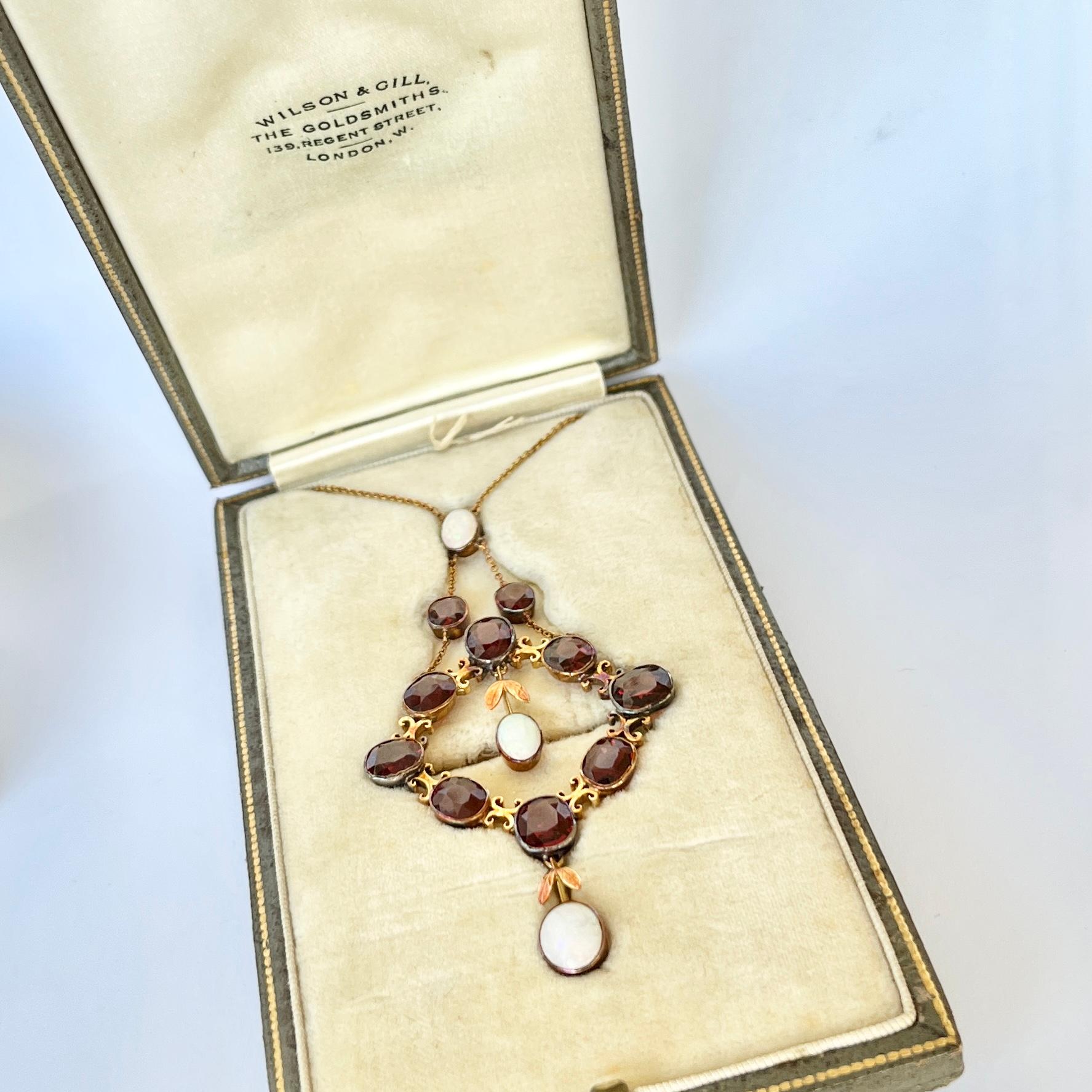 This sweet pendant holds garnets and colourful opals. This pendant could be worn as a brooch also. The amount of detail on this pendant is simply stunning. Modelled in 9ct gold and comes in original fitted box. 

Drop from loop: 72mm
Pendant Width:
