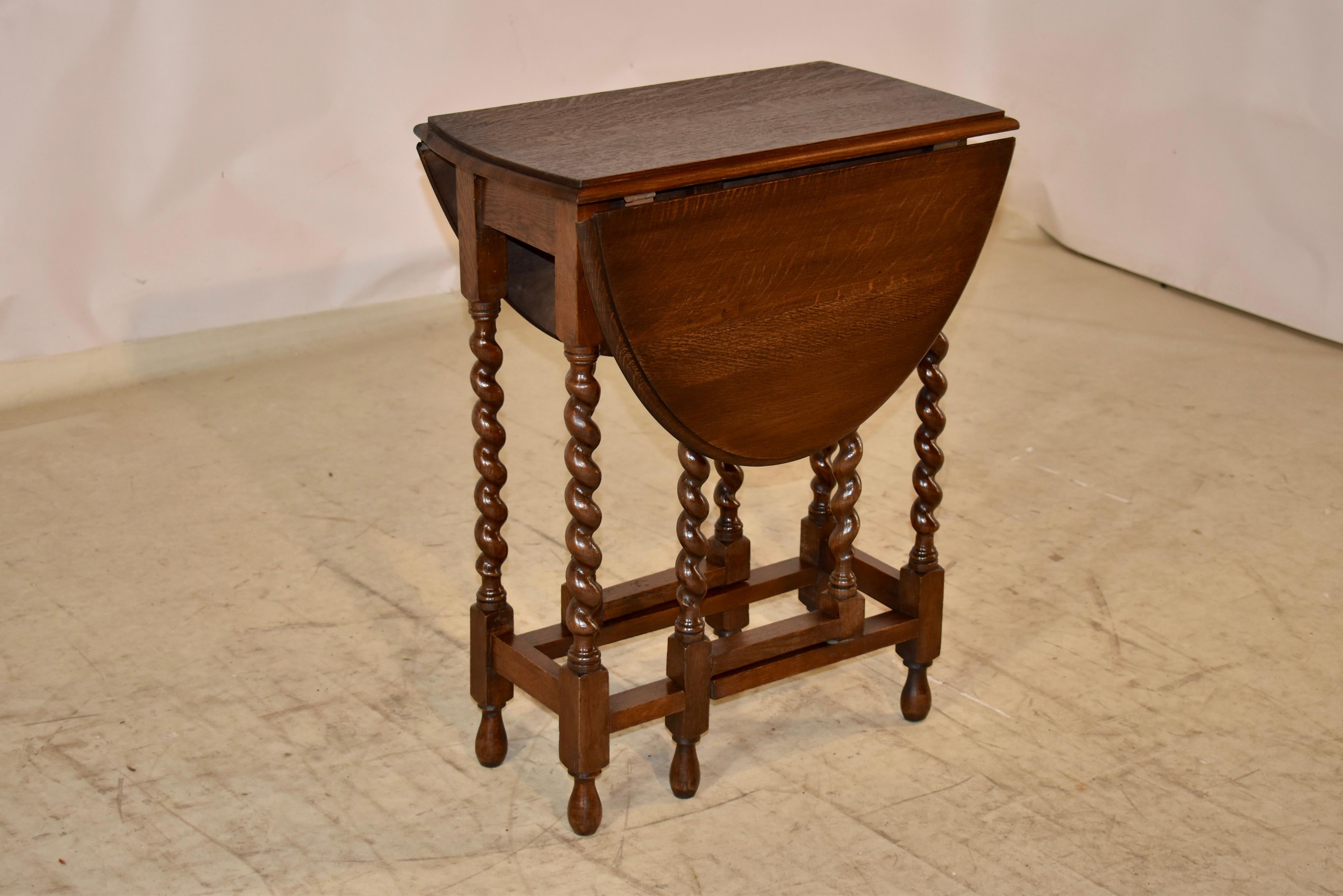 English Edwardian oak side table, circa 1900.  The top has a beveled edge surrounding a lovely grained top.  This follows down to a simple apron, and is supported on hand turned Harley twist legs, joined by simple stretchers and raised on hand
