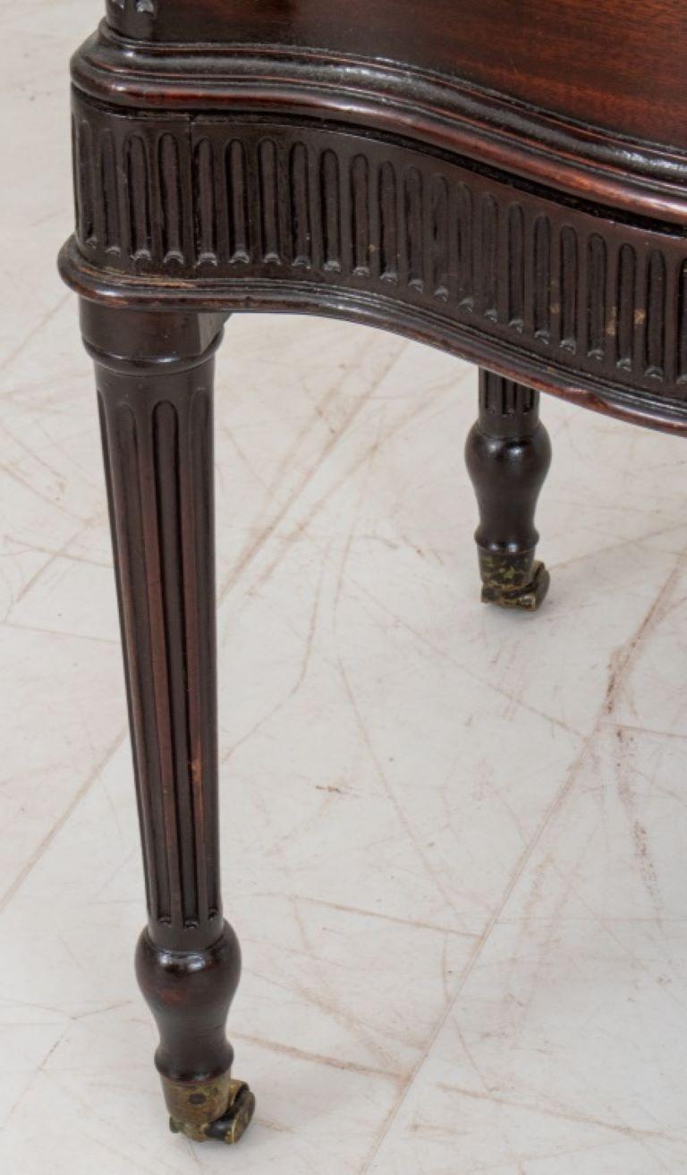 Edwardian period Georgian revival mahogany cellarette on stand, the serpentine fronted hinged lidded cellarette with interior copper liner, on a conforming stand with carved rails and tapering columnar stop fluted legs on casters. 

Dealer: S138XX