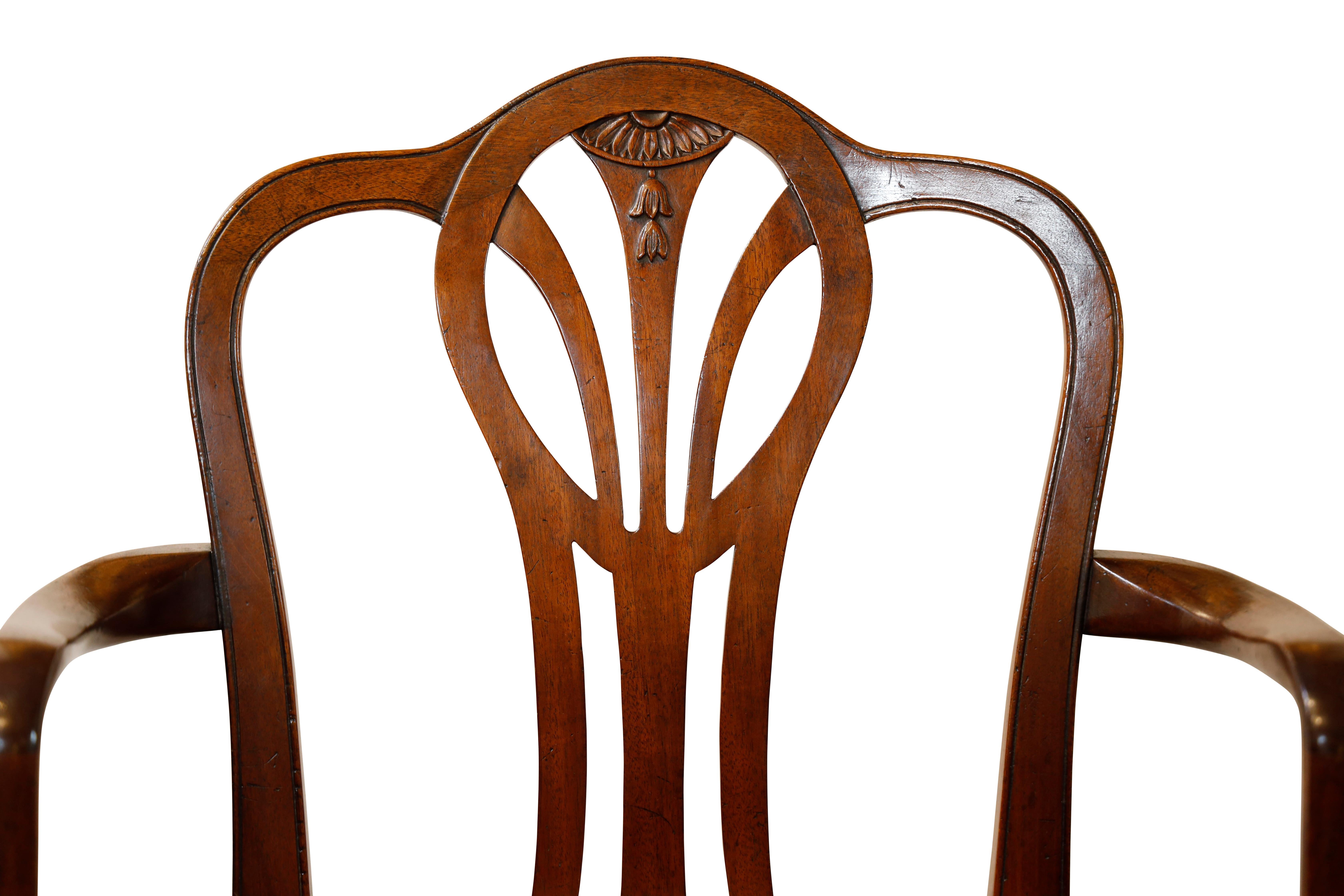 Set of 12 Georgian Style Dining Chairs, 10 sides/ 2 arms.  Shaped backs with central splats and upholstered seats.  Splat features florette carving and bell flowers.  Square, tapered legs joined by 