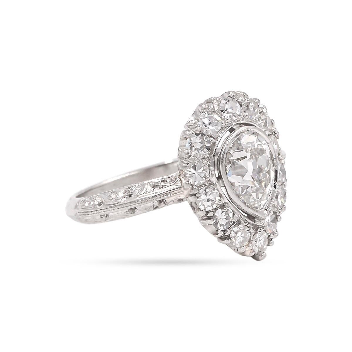 A unique Late Edwardian Era Cluster Ring. Composed of platinum. This Edwardian cluster ring (circa 1915) features a center stone 1.10 Ct. Antique Pear Shape Diamond. Surrounded by 14 Old Single Cut Diamonds weighing 0.50 Ct. in total. The shank of