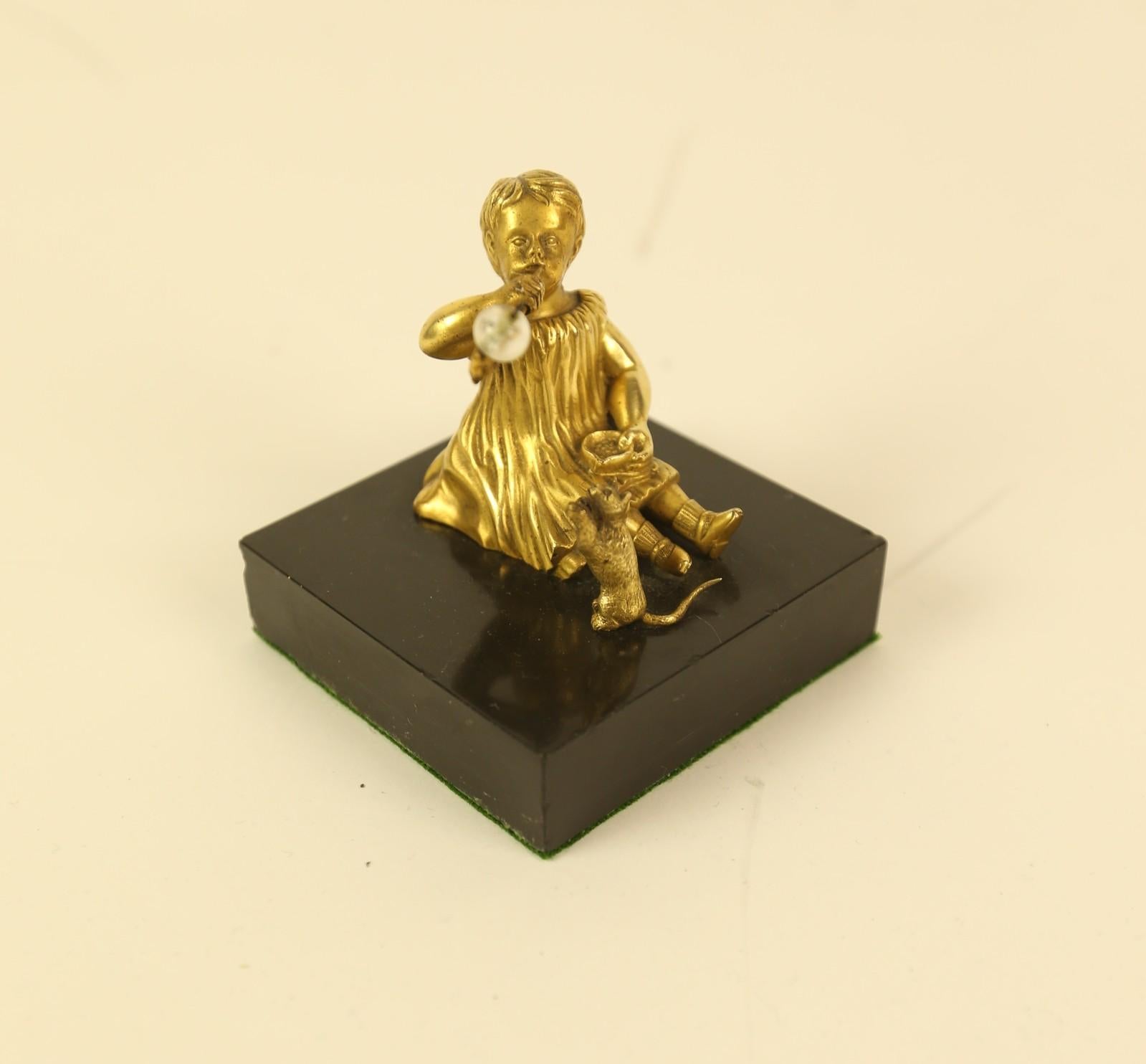 Edwardian Gilt Bronze Figure of a  seated Girl Blowing bubbles, 
With A figure of a kitten bedside her
Glass bubble
sitting on Square Black slate Base
Green baize at base
good quality detailed casting