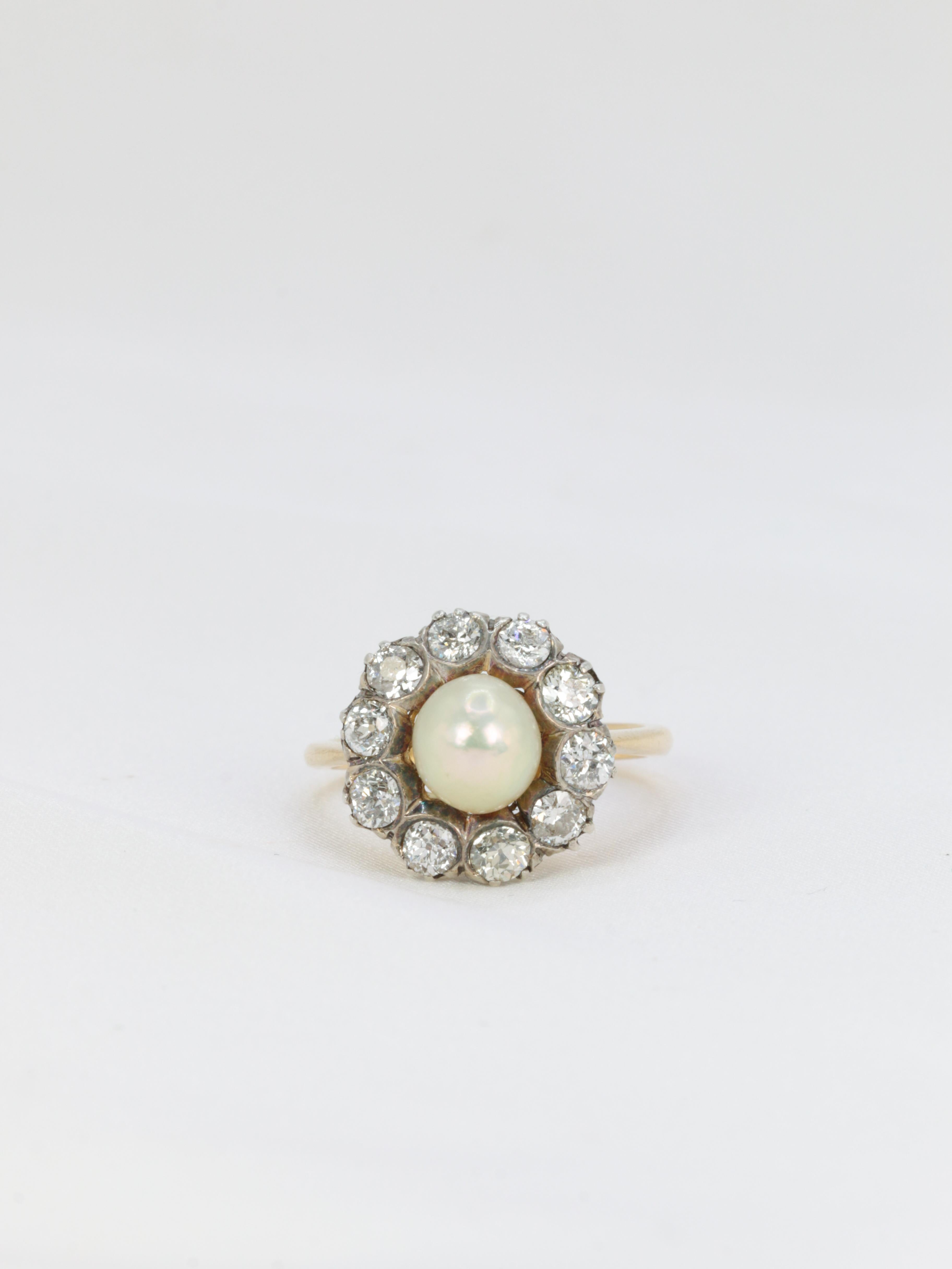 Antique cluster ring in 18Kt gold (750°/°°) and silver set in its center with a natural pearl (very slightly baroque cream-coloured) and ten fine quality old mine cut diamonds for a total weight of approximately 1.2 ct.
Edwardian work from the 19th