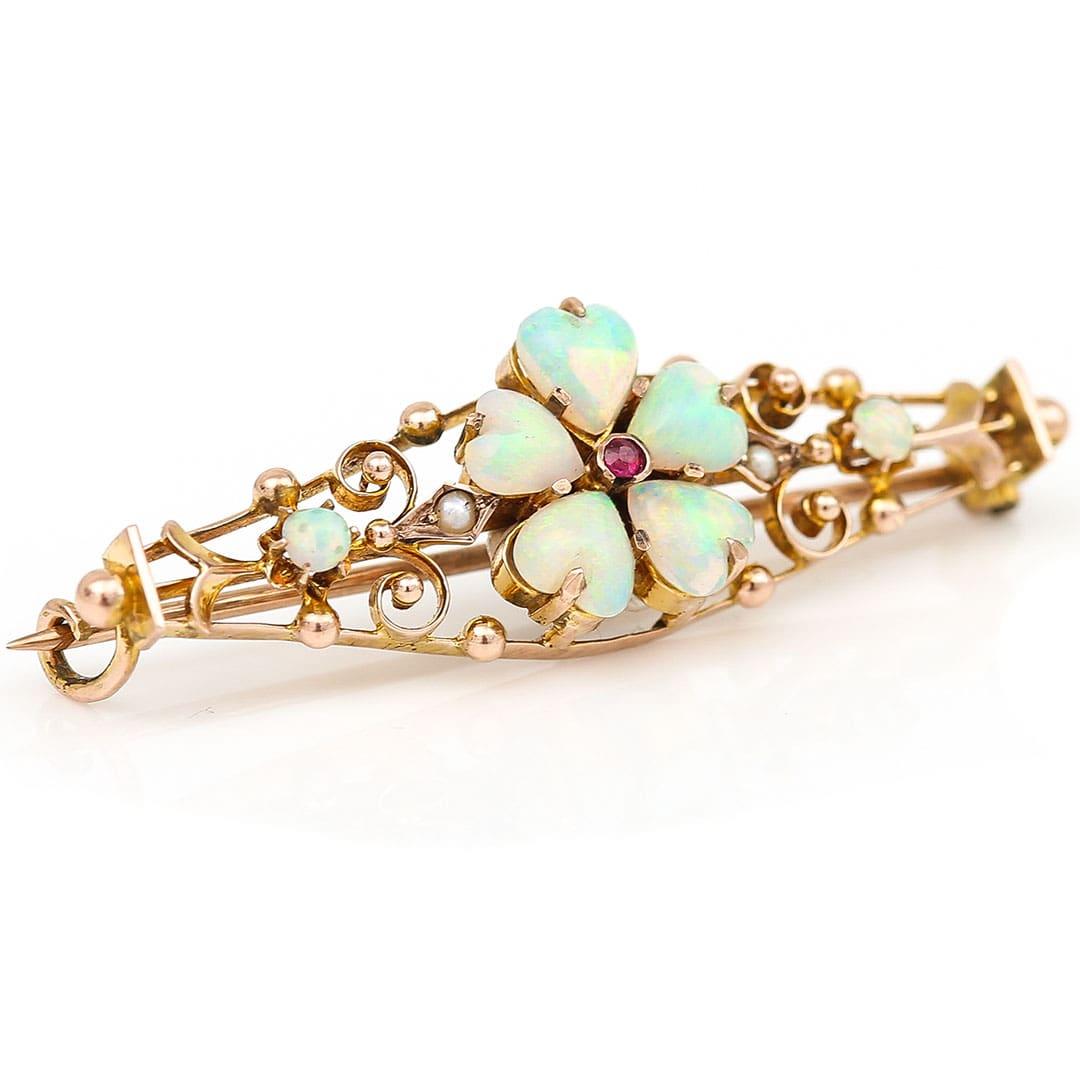 A stunning early 20th century bar brooch hand crafted in 9ct yellow gold dating from circa 1905 with a central set opal cluster with ruby and pearls. This wonderful piece evokes all the charm and appeal that fine antique jewellery has to offer. The