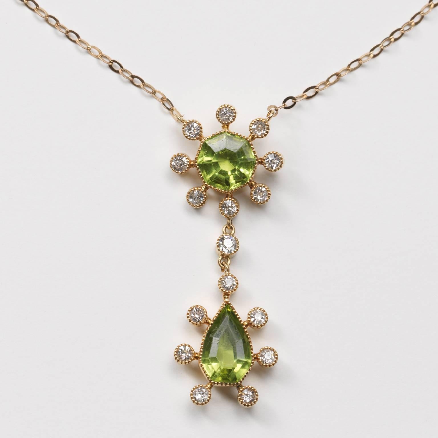 A gold necklace with a peridot and diamond pendant; an octagonal facetted peridot with eight old cut diamonds around it mille griffe set under two diamonds another peridot surrounded with old cut diamonds, mille griffe set, circa 1915, England, in