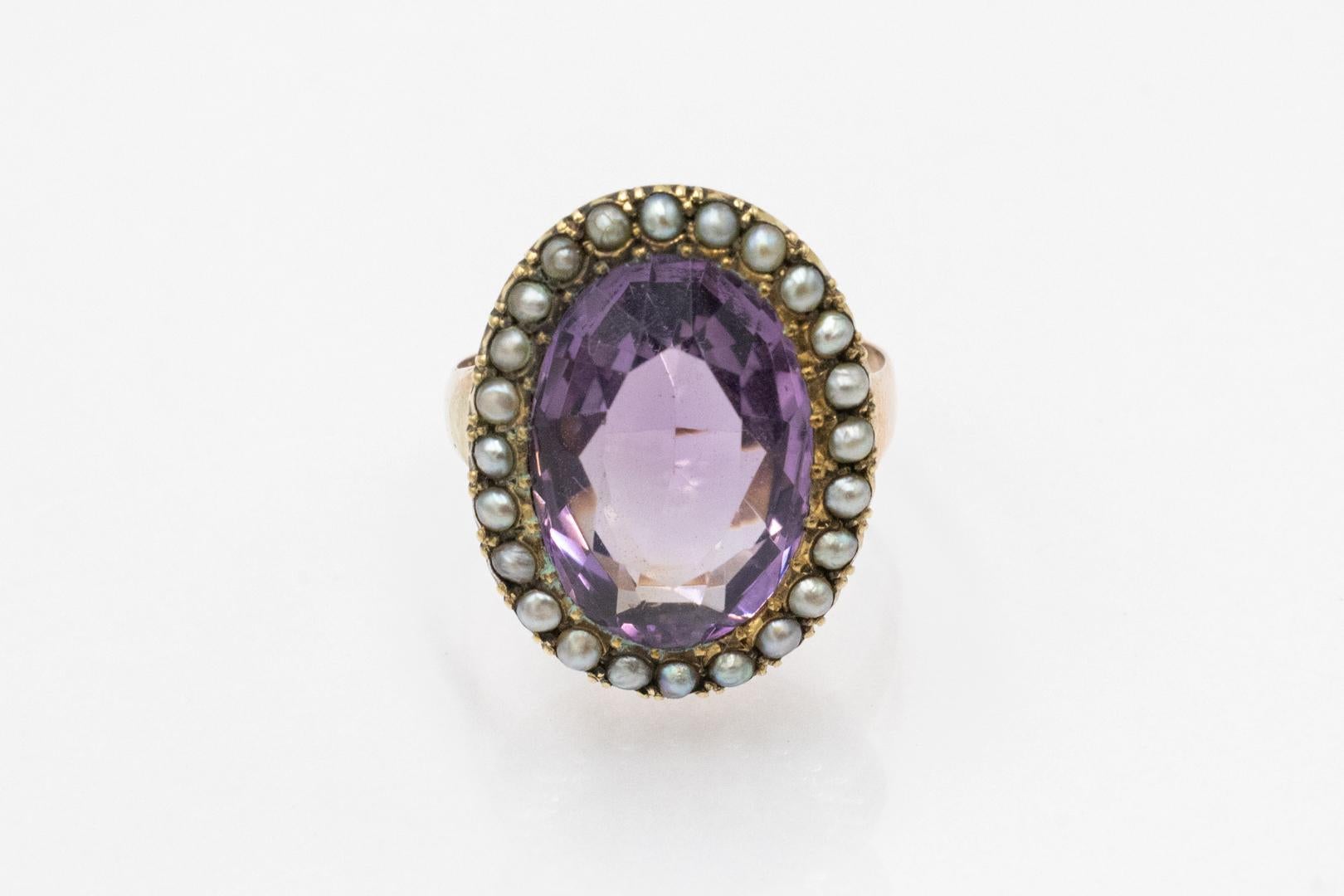 Antique Edwardian gold ring with amethyst and natural pearls, Great Britain, early 20th century

Made of 9-karat yellow gold (0.375 fineness)

Decorated with a majestic amethyst measuring 20 x 17mm surrounded by a crimson of 24 silver, natural