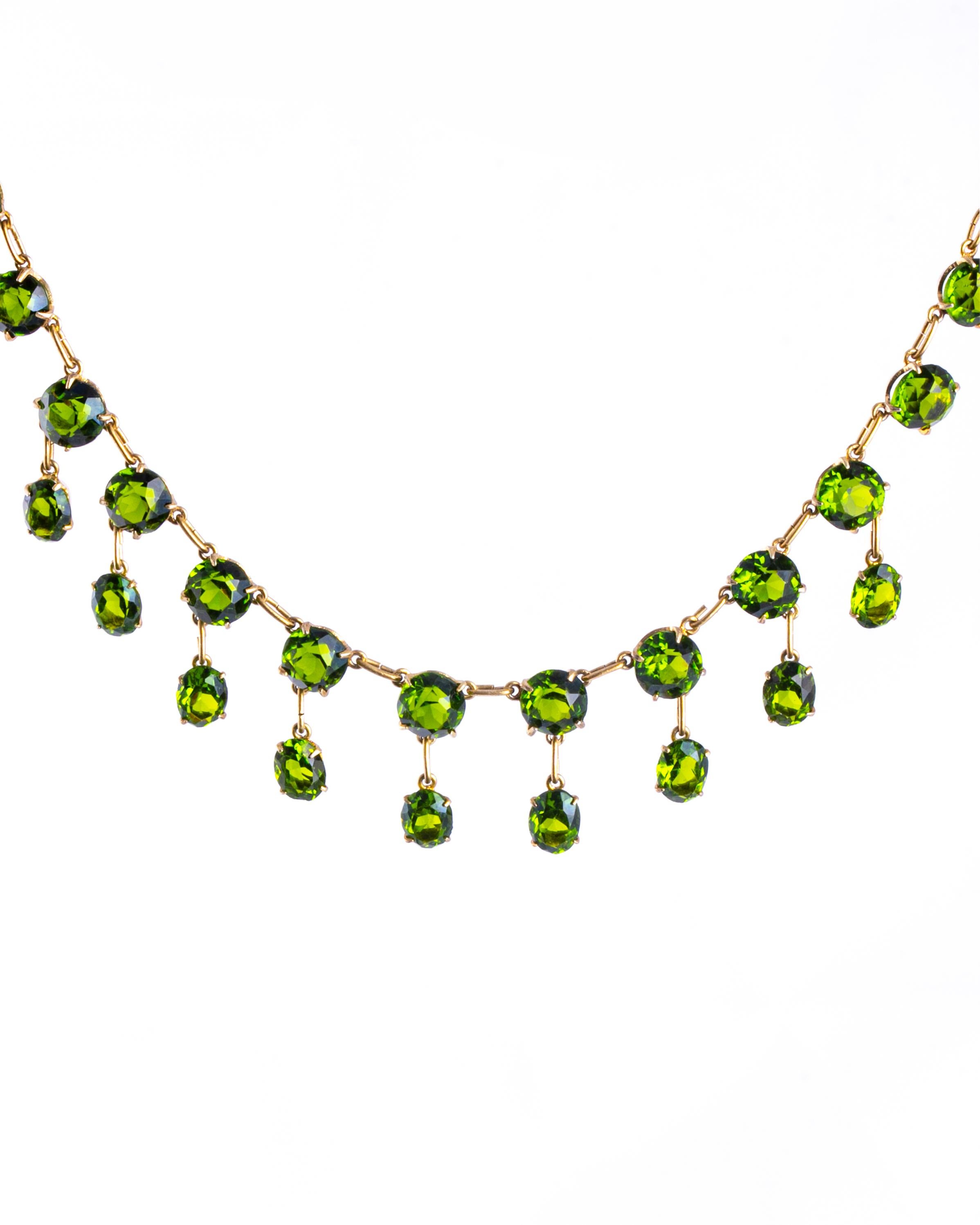 Die grünen Steine in dieser Halskette sind hell und funkeln. Sie sind in schlichte Krallenfassungen gefasst und mit einer zarten Kette verbunden, die in Silbervergoldung modelliert ist. 

Länge: 37cm
Fransenlänge: 20mm
Stein-Durchmesser: 7.5