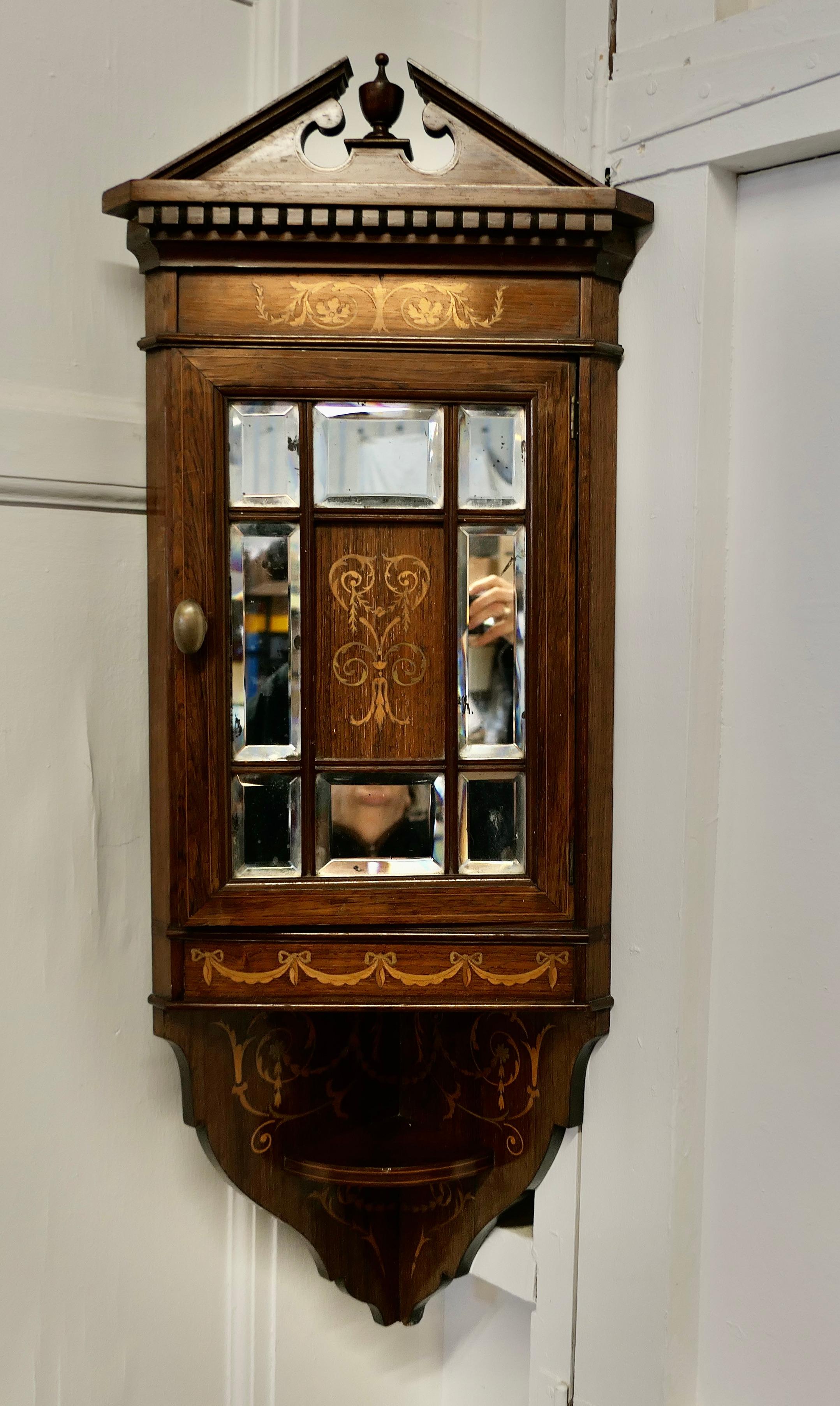 Edwardian Inlaid Corner Cupboard

A Very attractive Corner Cupboard the door of the cabinet has 8 Bevelled Mirror panels around a central inlaid panel, there is more inlaid decoration beneath where there is a little shelf bracket and at the top