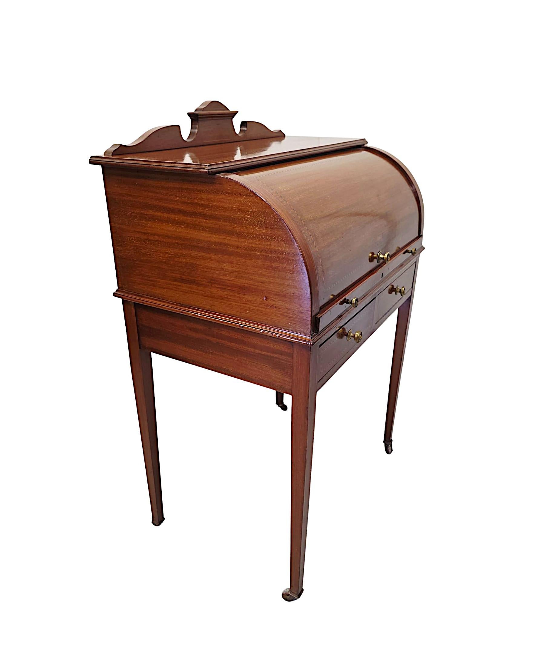 A stunning Edwardian well figured mahogany cylinder desk, finely carved and of exceptional quality, beautifully inlaid throughout with rich patination and fine grain.  The moulded inlaid top of rectangular form with shaped back gallery rail and
