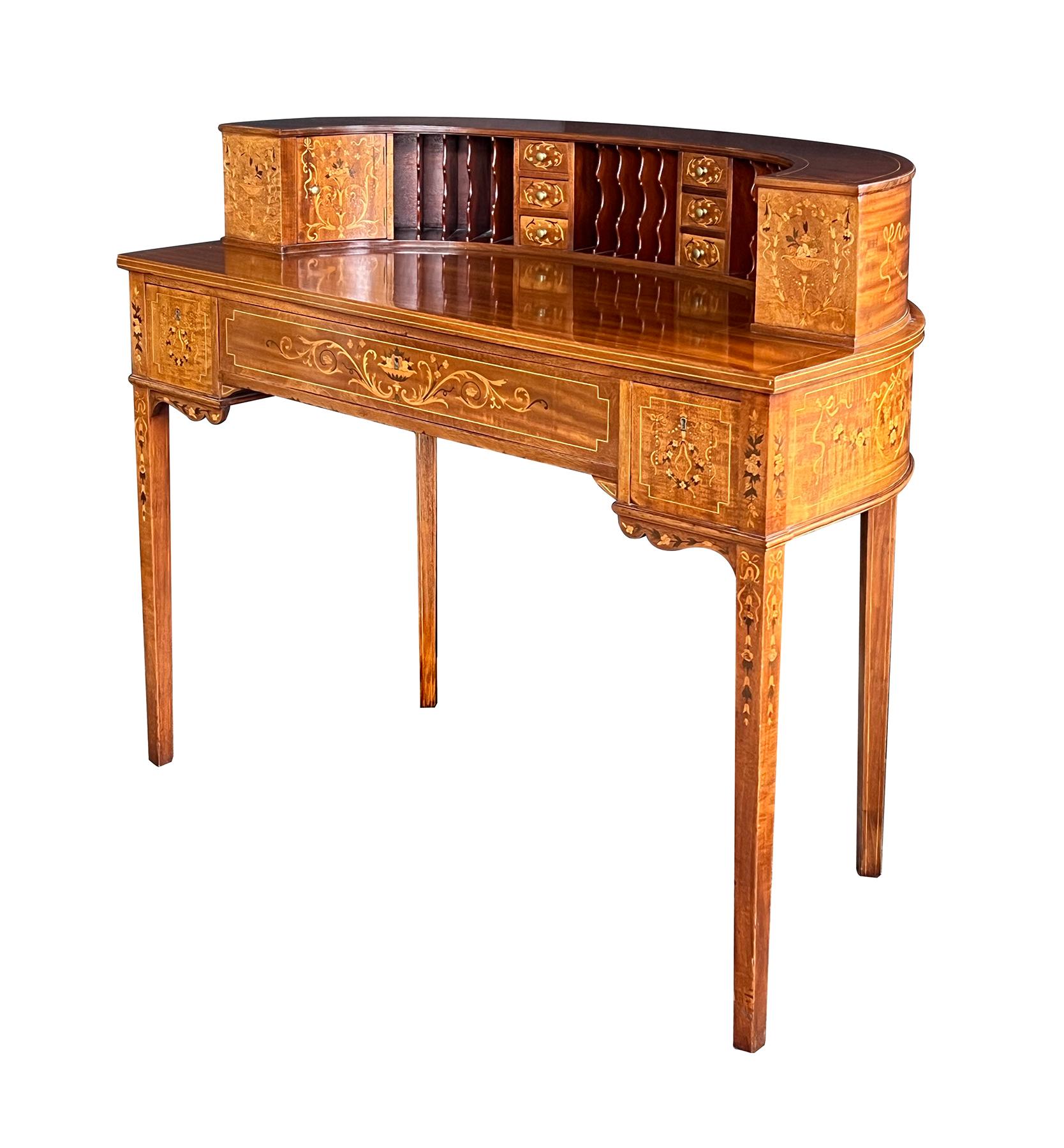 of U-shaped form and in the neoclassical taste with conforming writing surface surrounded by a raised level fitted with slots and drawers all flanked by hinged doors on either end; raised on square tapering supports; adorned overall with fine
