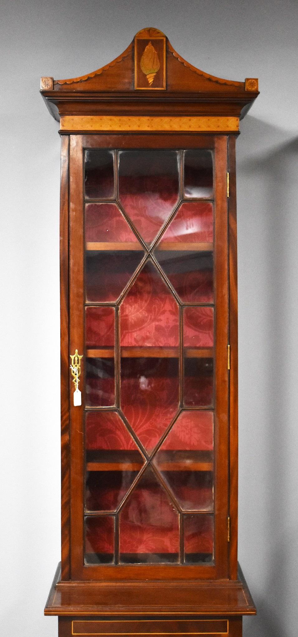 Edwardian Display cabinet in good condition with a pediment top with a nice shell inlay to the centre with a satinwood band underneath below this the glazed door when open reveals three shelves with a single drawer and cupboard below all with inlay