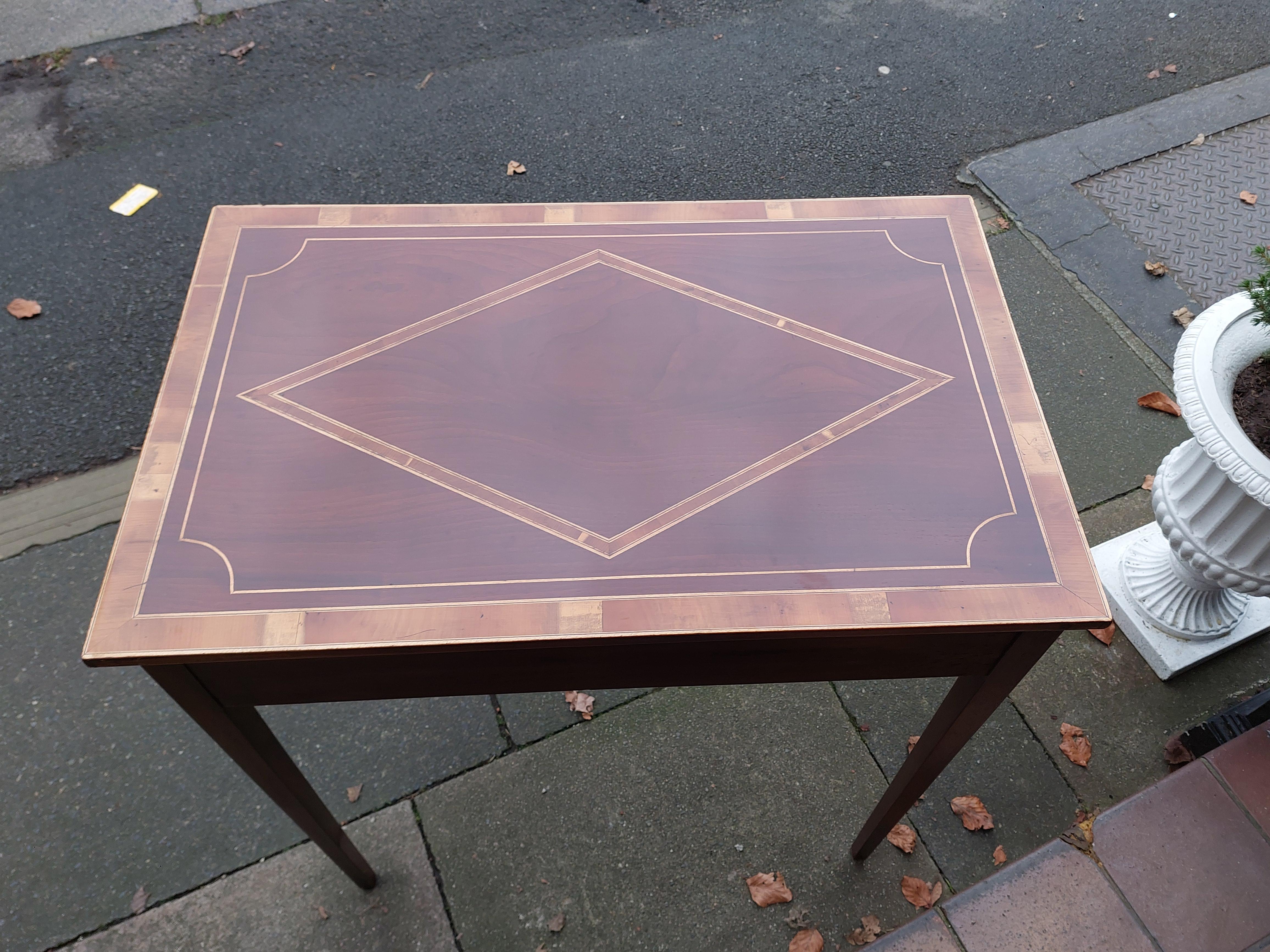 Mesa auxiliar de recibidor eduardiana de caoba con incrustaciones, estilo Sheraton, con tablero de madera de tejo entrecruzada, cajón de un friso y elevada sobre patas cónicas de sección cuadrada - 258 