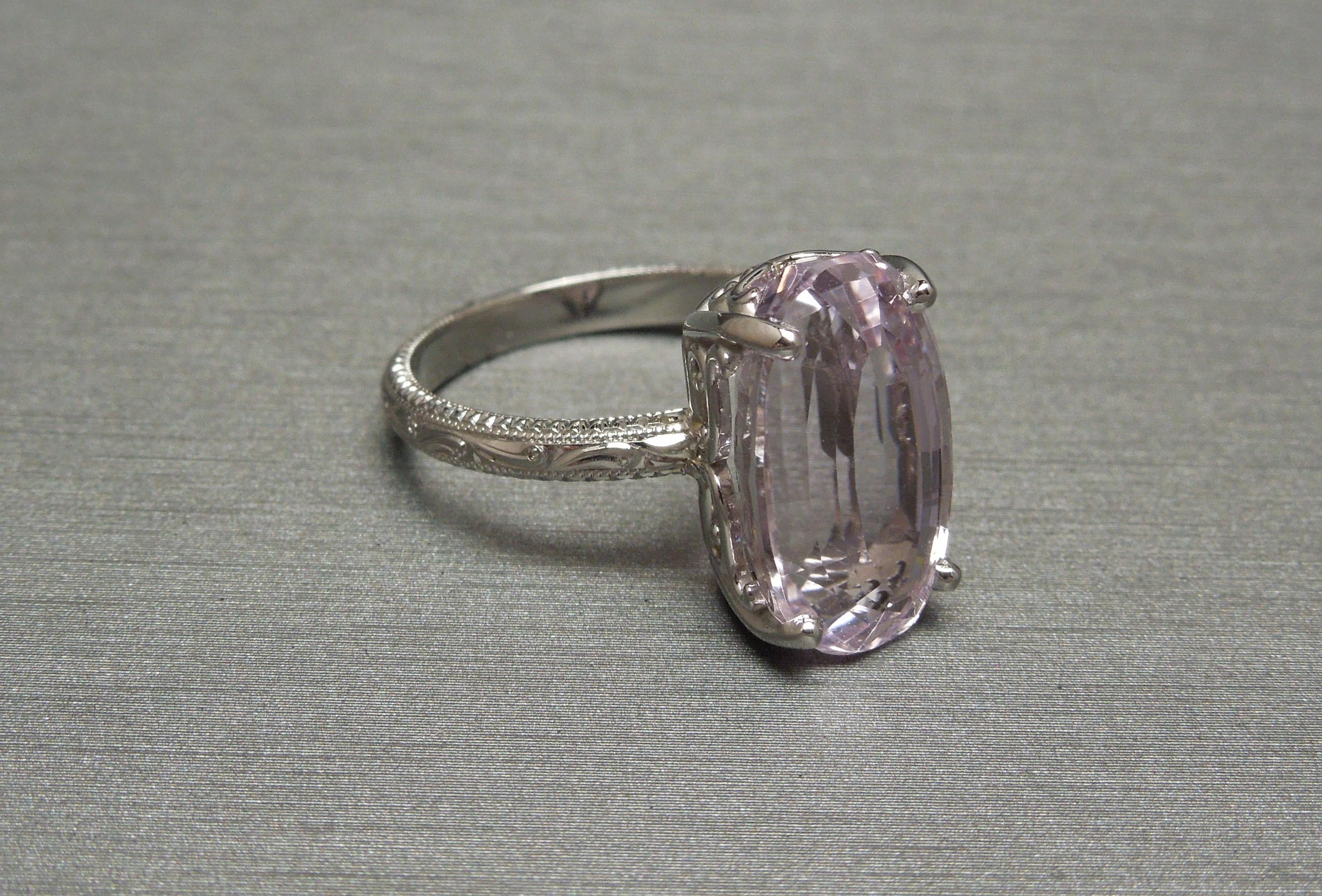 In a Classic Edwardian inspired design solitaire, featuring a 8.70 carat Elongated Oval cut Natural Brilliant Kunzite measuring 15.7mm x 9.2mm x 7.3mm. Securely set in a four-prong Filigree setting. Band accented with intricately detailed Hand