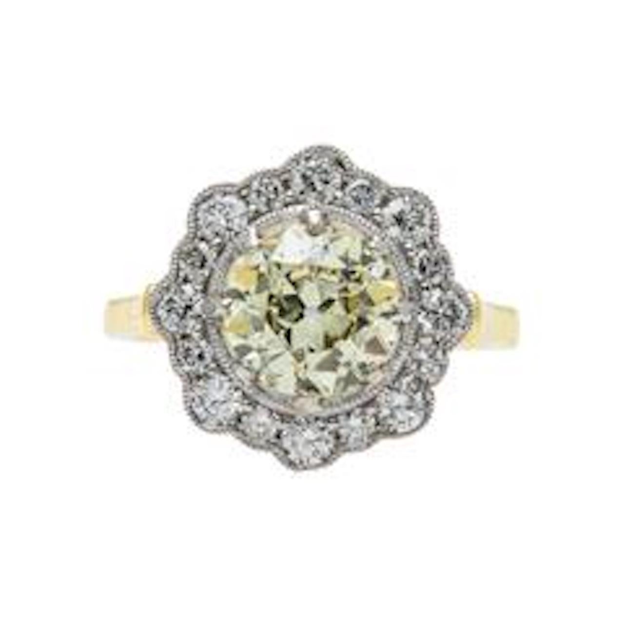 This is a newly-made engagement ring modeled after an original Edwardian era ring. The platinum topped 18k yellow gold ring centers a beautiful Guild Lab certified 1.85ct Fancy Light Yellow Old European cut diamond. The incredibly feminine ring is
