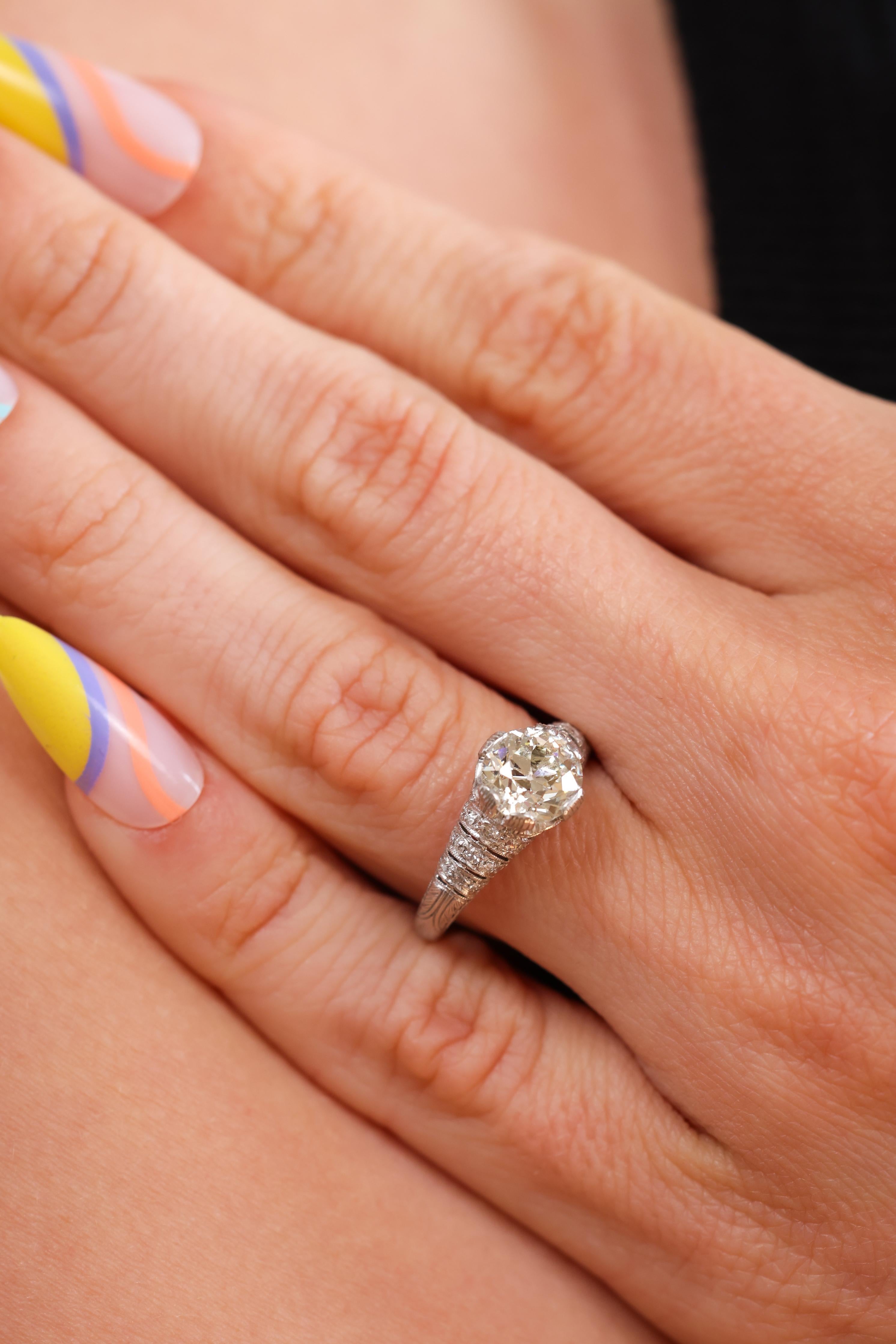 This is a lovely Edwardian-inspired platinum and diamond engagement ring that was most likely made in the last 20 years. This stunning ring centers a 1.64ct GIA certified Old European Brilliant Cut diamond graded M color and VS1 clarity. Havenhurst