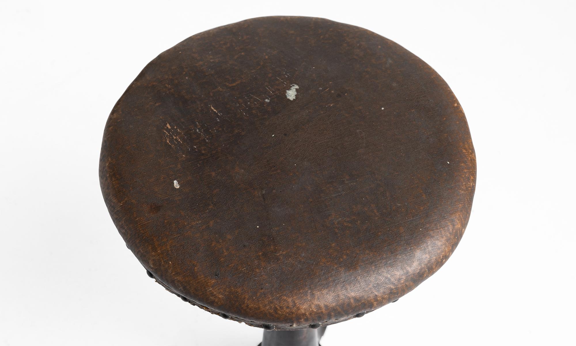 Cast iron stool with original leatherette upholstery. Height is adjustable.