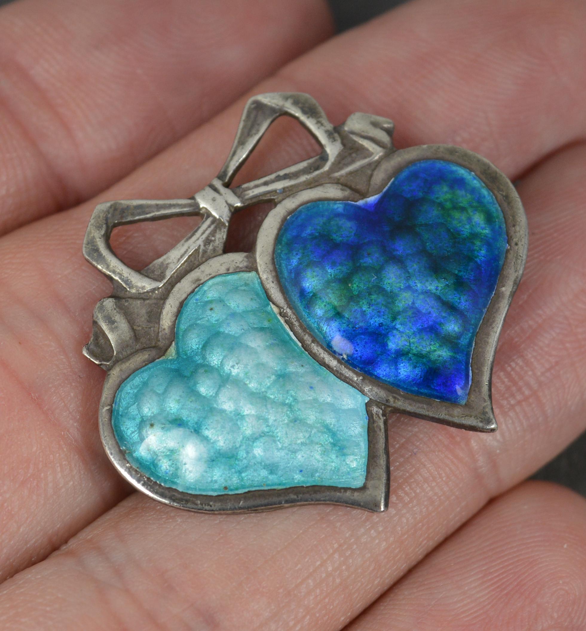 A fine Edwardian period brooch.
Solid silver example.
Designed with two hearts, each full of wonderful blue enamelling and a ribbon bow top.

Hallmarks ; full English hallmarks
Weight ; 6.0 grams
Size ; 30mm x 26mm approx
Condition ; Very good.