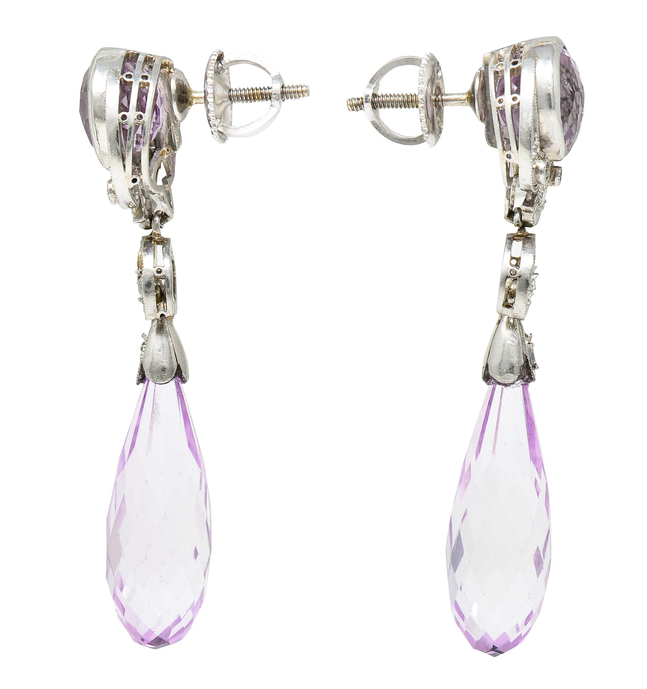 Earring surmounts feature 7.0 mm round checkerboard cut kunzite spodumene. Bezel set with scrolling details and suspending an articulated drop. Featuring briolette pampel drops measuring approximately 7.0 x 19.0 mm. With a scalloped platinum top
