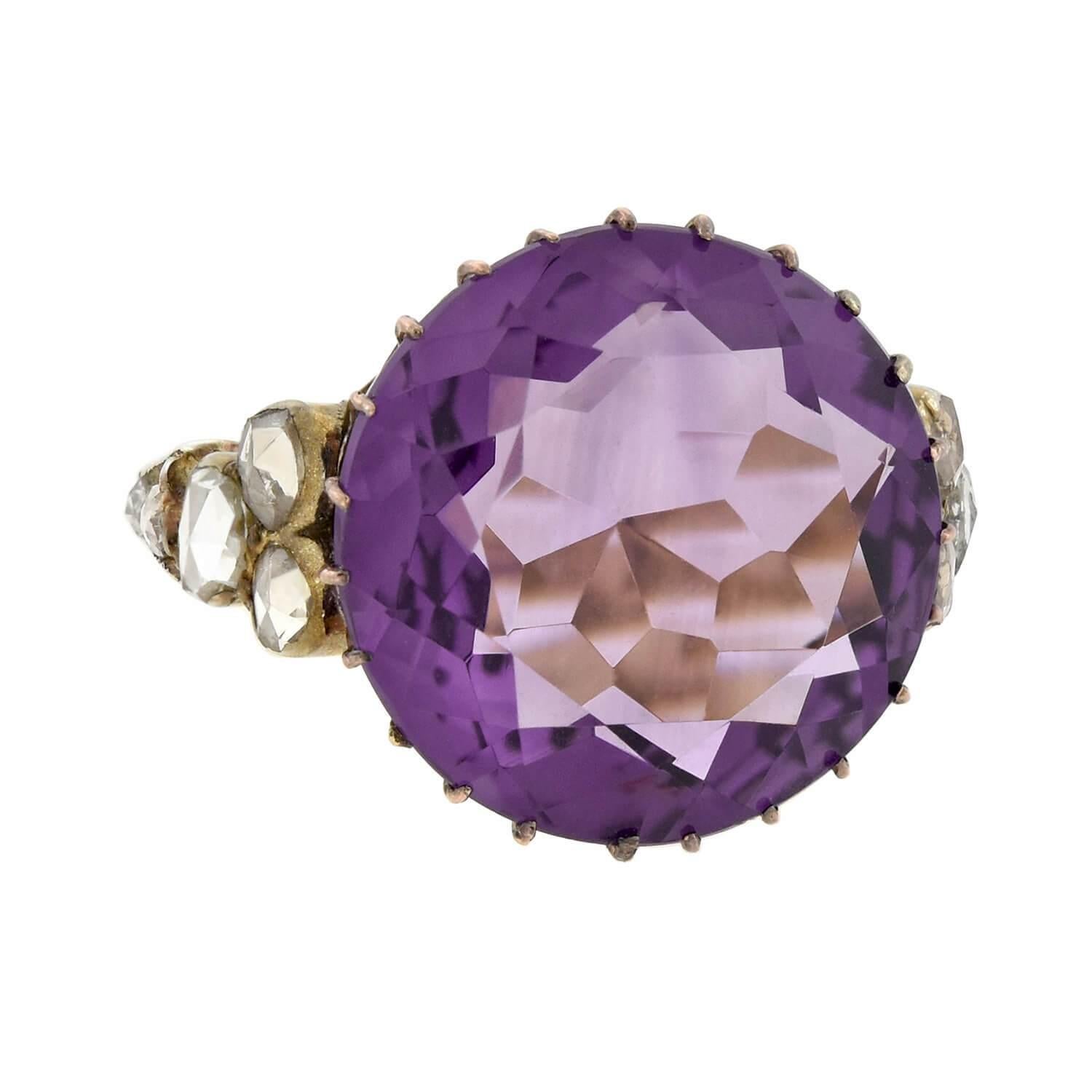 A gorgeous amethyst and diamond ring from the Edwardian (ca1910s) era! Crafted in 18kt gold, this striking piece features a substantial 14ct amethyst held within rose gold prongs. The vibrant, round stone has a vivid, royal purple hue and facets
