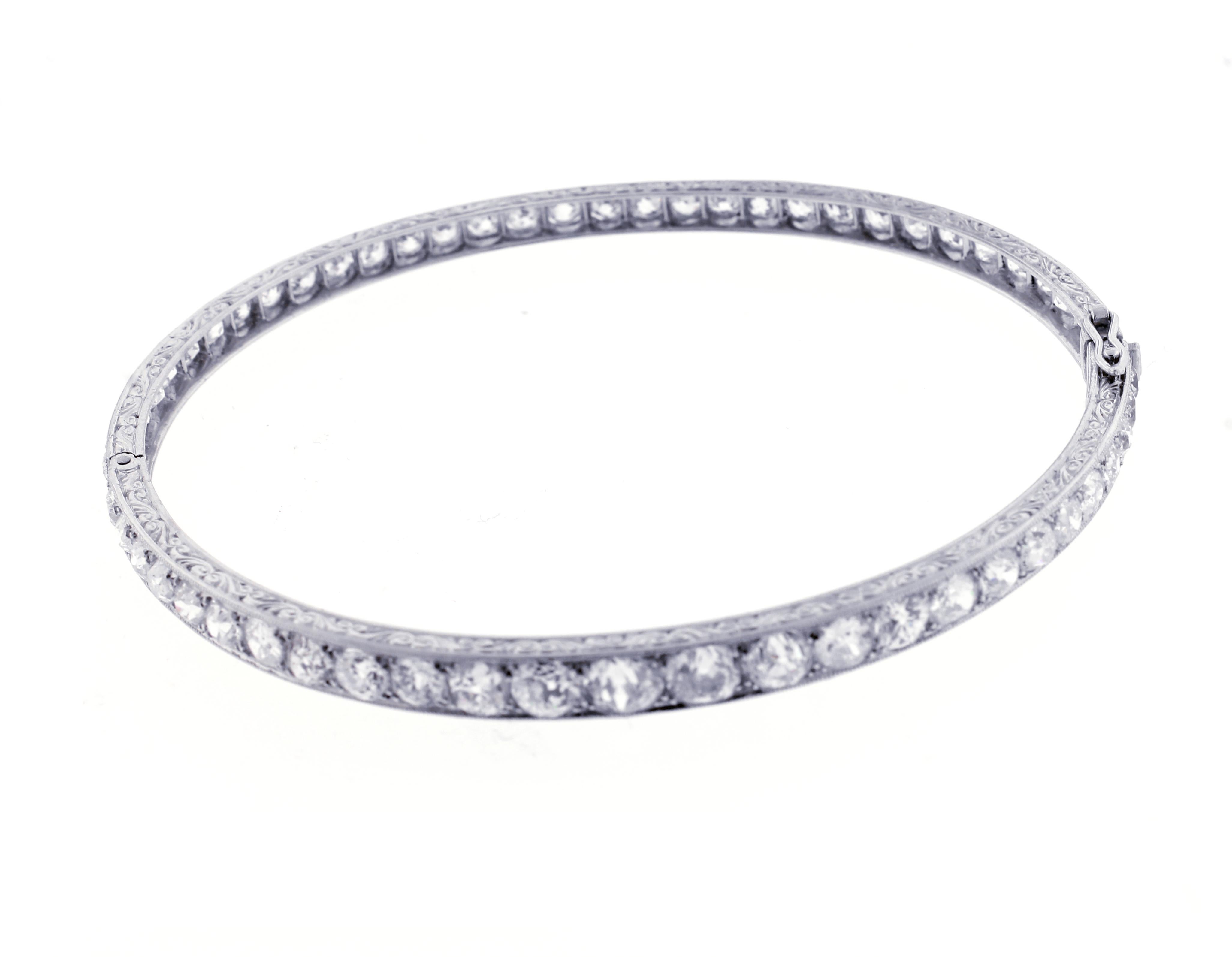 

A wonderful example of early 2oth century design and craftsmanship This platinum bracelet is comprised of a blend of fifty-eight old European and old mine cut diamonds weighing approximately 9 carats. The side of the bangle is intricately