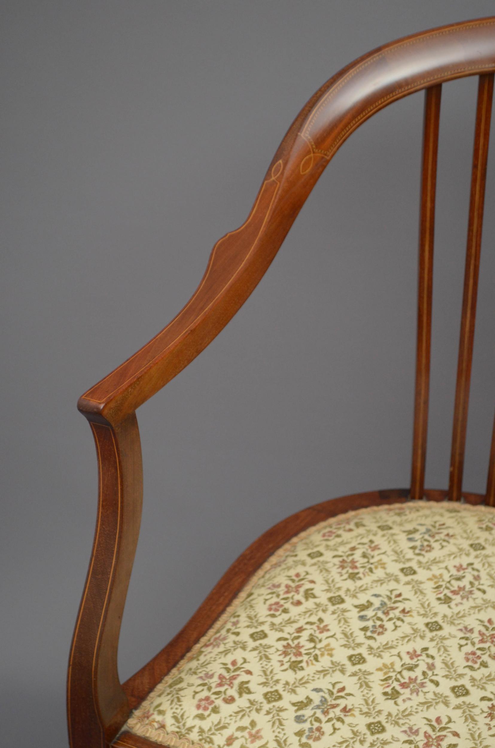 Sn5037 Edwardian, mahogany occasional chair, having curved and amboyna inlaid top rail with satinwood string inlaid slats below, open arms and serpentine seat, all raise on elegant string inlaid legs terminating in pad feet. This antique armchair