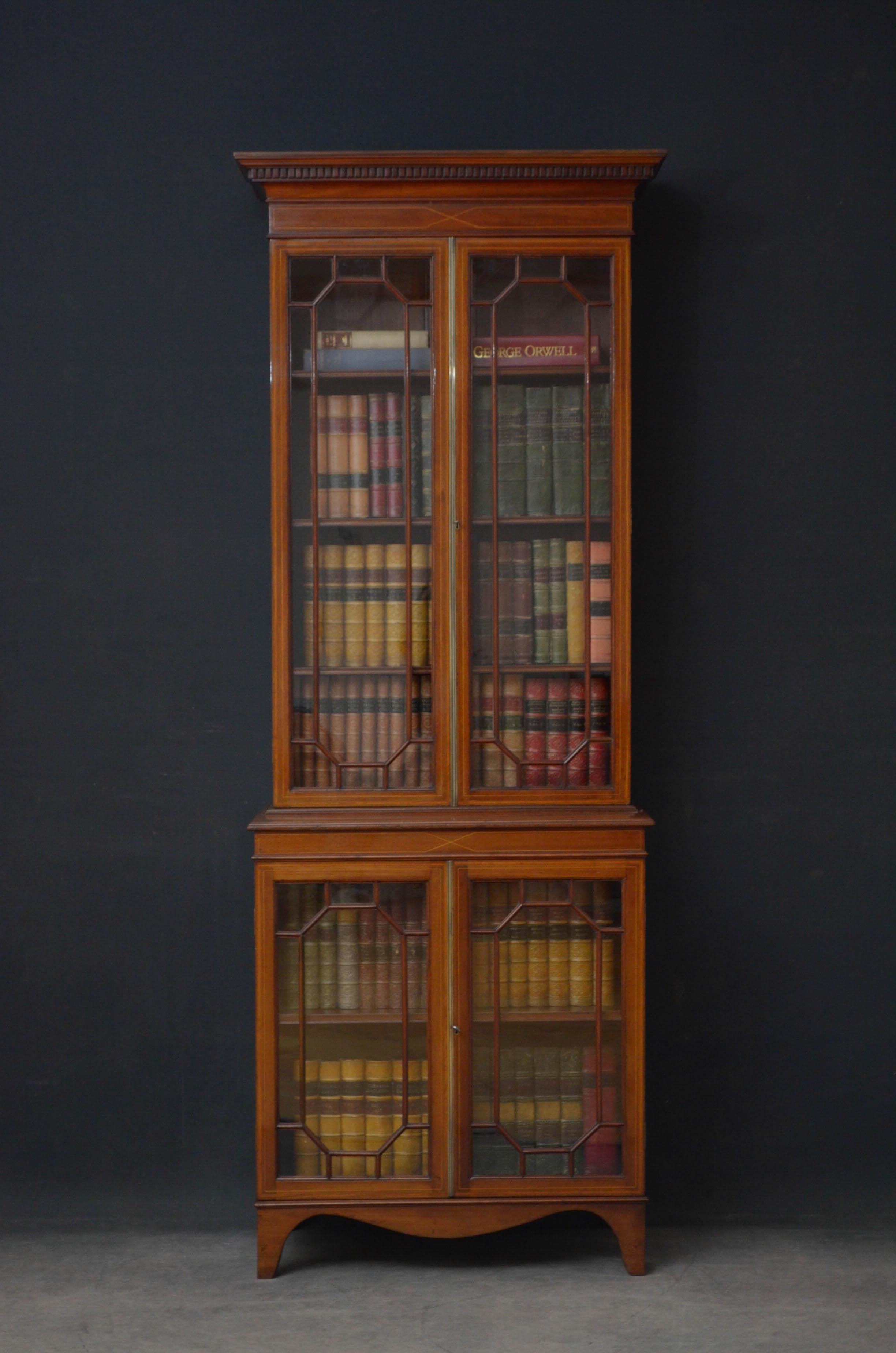 Sn4820 Edwardian mahogany glazed bookcase, having cavetto cornice above satinwood inlaid frieze and a pair of astragal glazed doors with brass centre beading and original working lock, enclosing 3 height adjustable shelves. Projecting base having