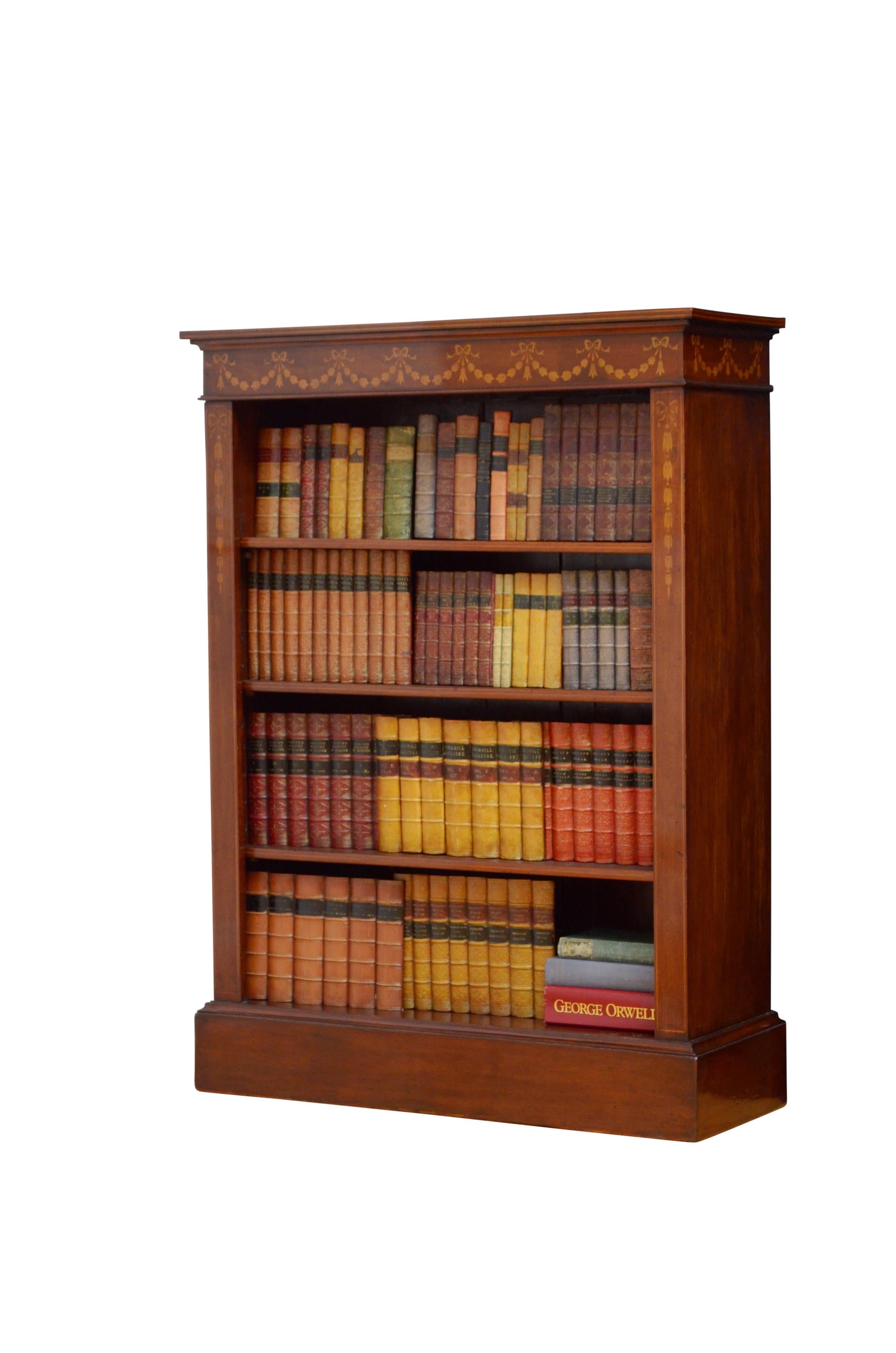 K0508 Attractive Edwardian open bookcase in mahogany, having satinwood string inlaid top above swag inlaid frieze and three height adjustable shelves, all flanked by hare bell inlaid pilasters, standing on plinth base. This antique bookcase has been