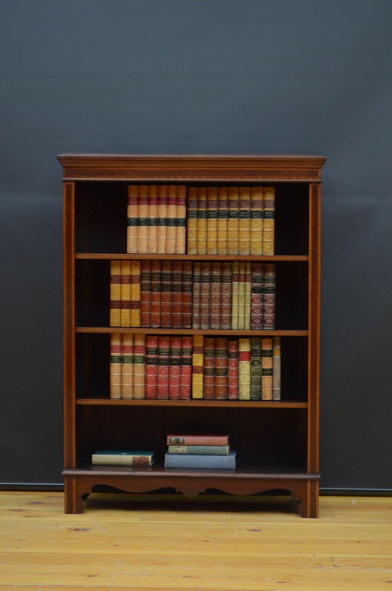 Sn5347 Edwardian mahogany open bookcase, having moulded top with crossbanded edge above crossbanded frieze and three height adjustable shelves flanked by satinwood crossbanded pilasters, all standing on shaped plinth base. This antique bookcase is