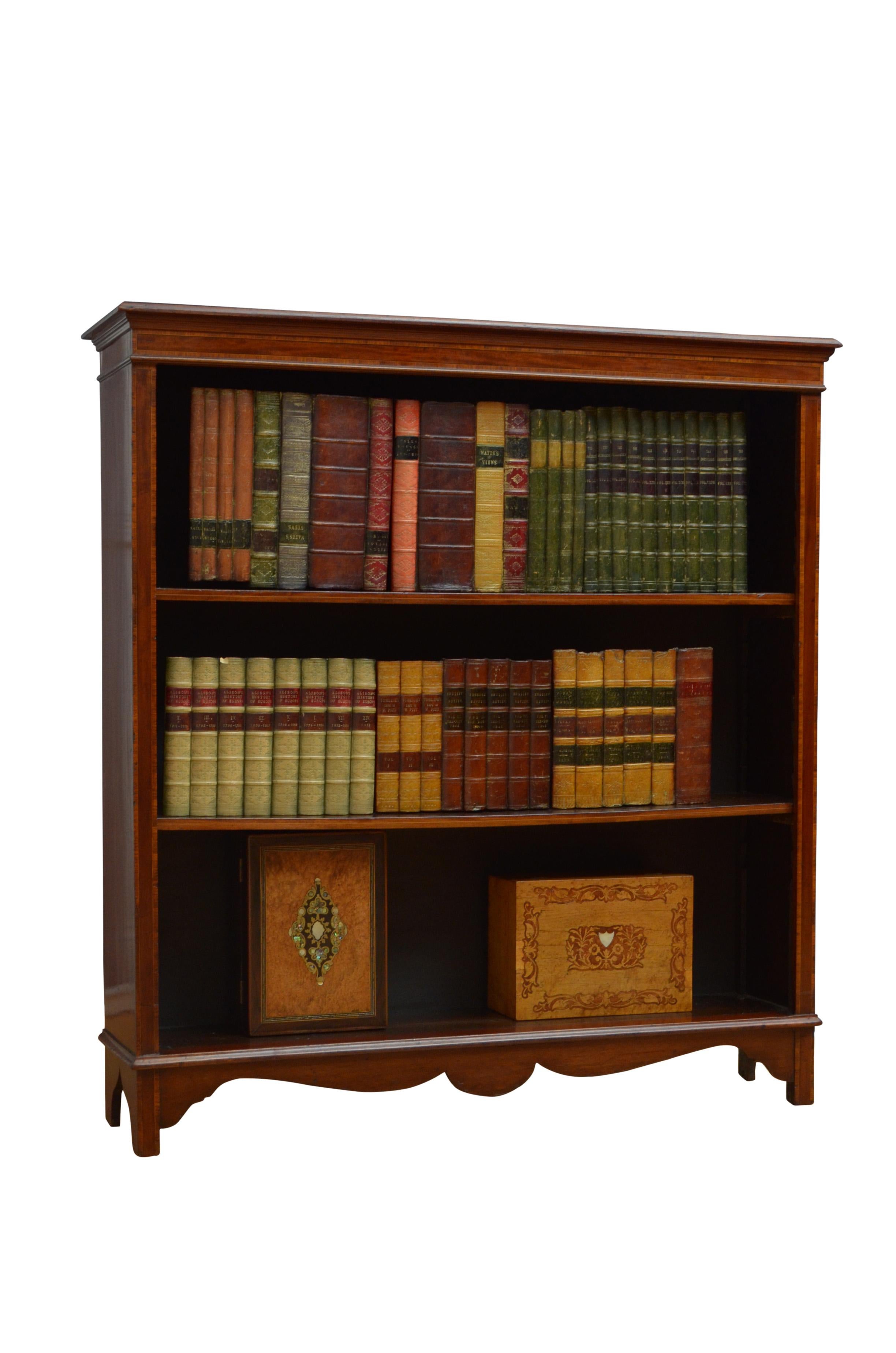 0591 Edwardian mahogany bookcase, having figured mahogany top with satinwood crossbanded and moulded edge above crossbanded frieze and two height adjustable shelves, all flanked by satinwood crossbanded pilasters, standing on bracket feet united by
